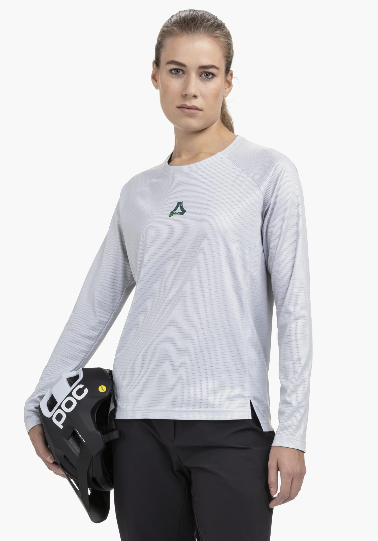 Longsleeve Style Koitere WMN in grey, shown on a model against a neutral background. The model faces the camera directly while holding a helmet. The subtle Schöffel logo is clearly visible on the chest.