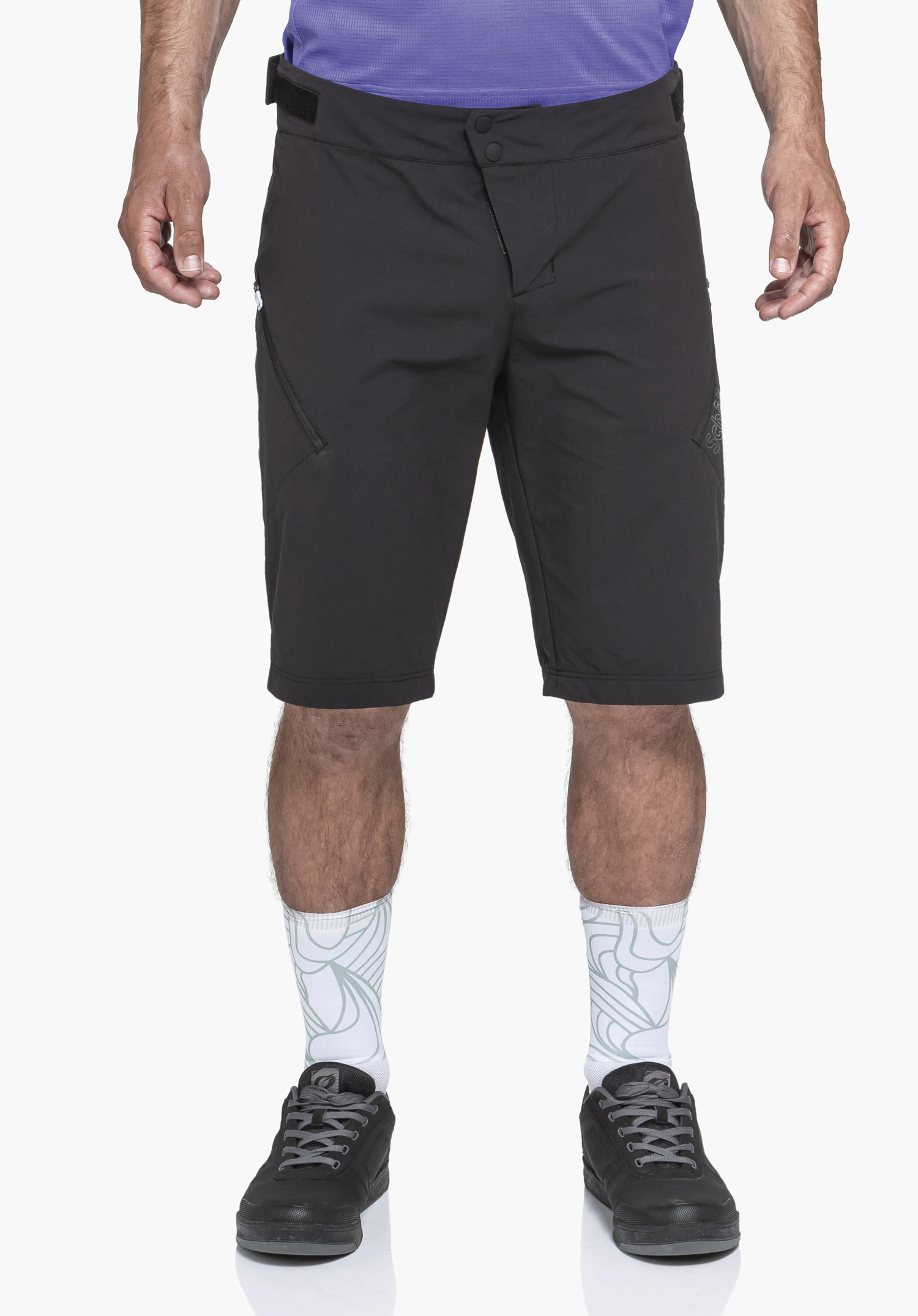 Shorts Style Puula MNS black knee-length shorts worn by a standing person; white socks with light green pattern, black shoes; neutral white studio background.