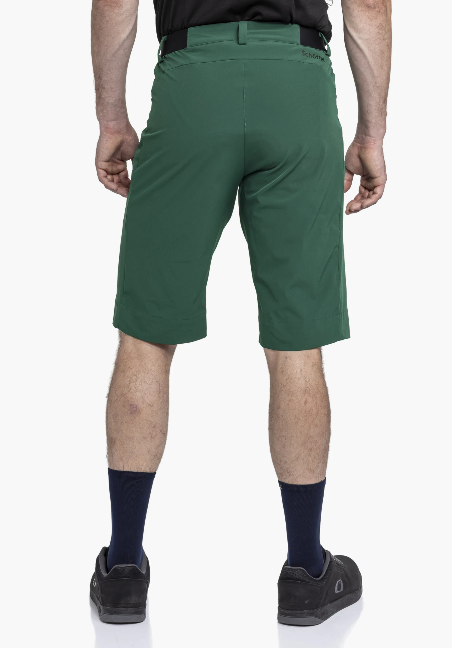 Shorts Style Keitele MNS in green. The model is presented from the back view against a neutral background. The shot highlights the fit and features the Schöffel logo clearly visible on the waistband.