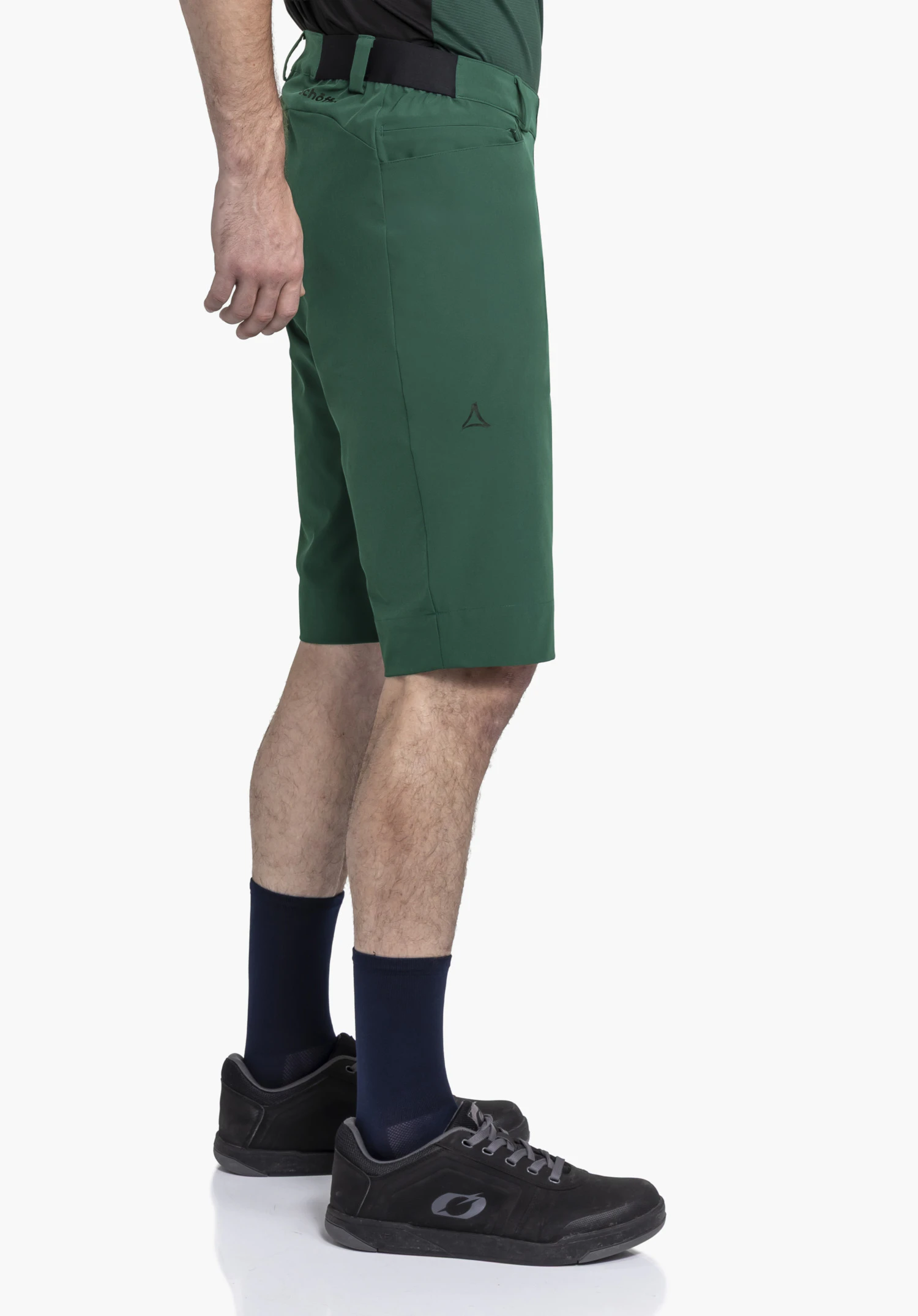 Shorts Style Keitele MNS in a rich green: A model showcases the shorts in a side profile against a neutral background, highlighting the subtle Schöffel logo on the leg.