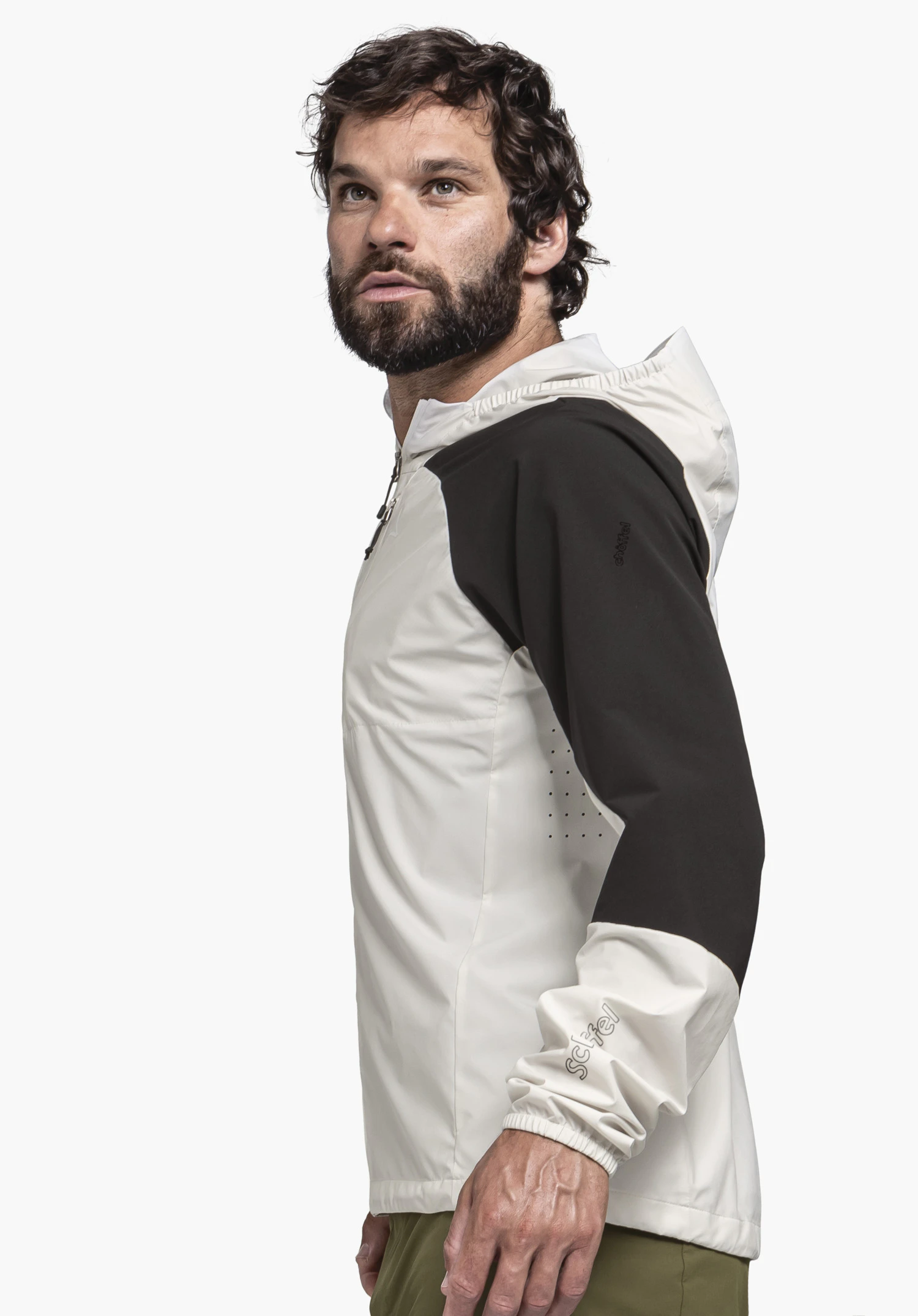 Hybrid Jk Style Mamry MNS in nature: A male model is standing sideways against a neutral background. The jacket in a subtle nature tone is accented by black sleeves, featuring the clearly visible Schöffel logo on the forearm.
