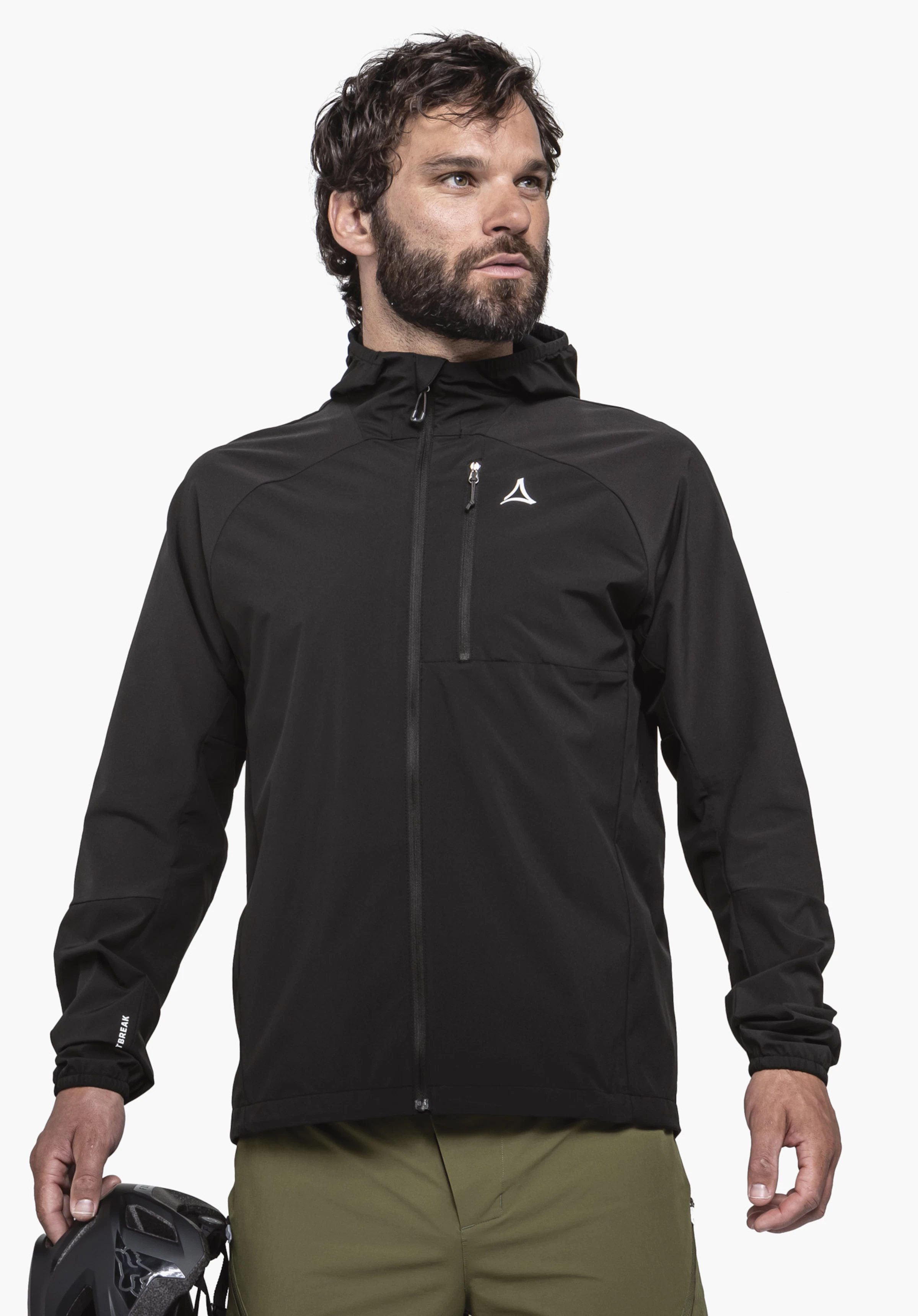 Hybrid Jk Style Mamry MNS in het zwart op een model. Het model staat frontaal, draagt de jas met een zichtbaar Schöffel-Logo op de borst en houdt een fietshelm vast, tegen een neutrale achtergrond.