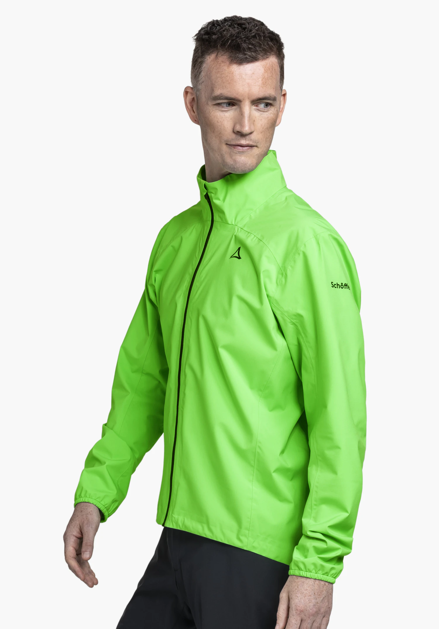 Jacket Style Lurbek MNS in vibrant green, worn by a model standing in a side-profile pose. Set against a neutral background, the Schöffel logo is clearly visible on the chest and upper arm.