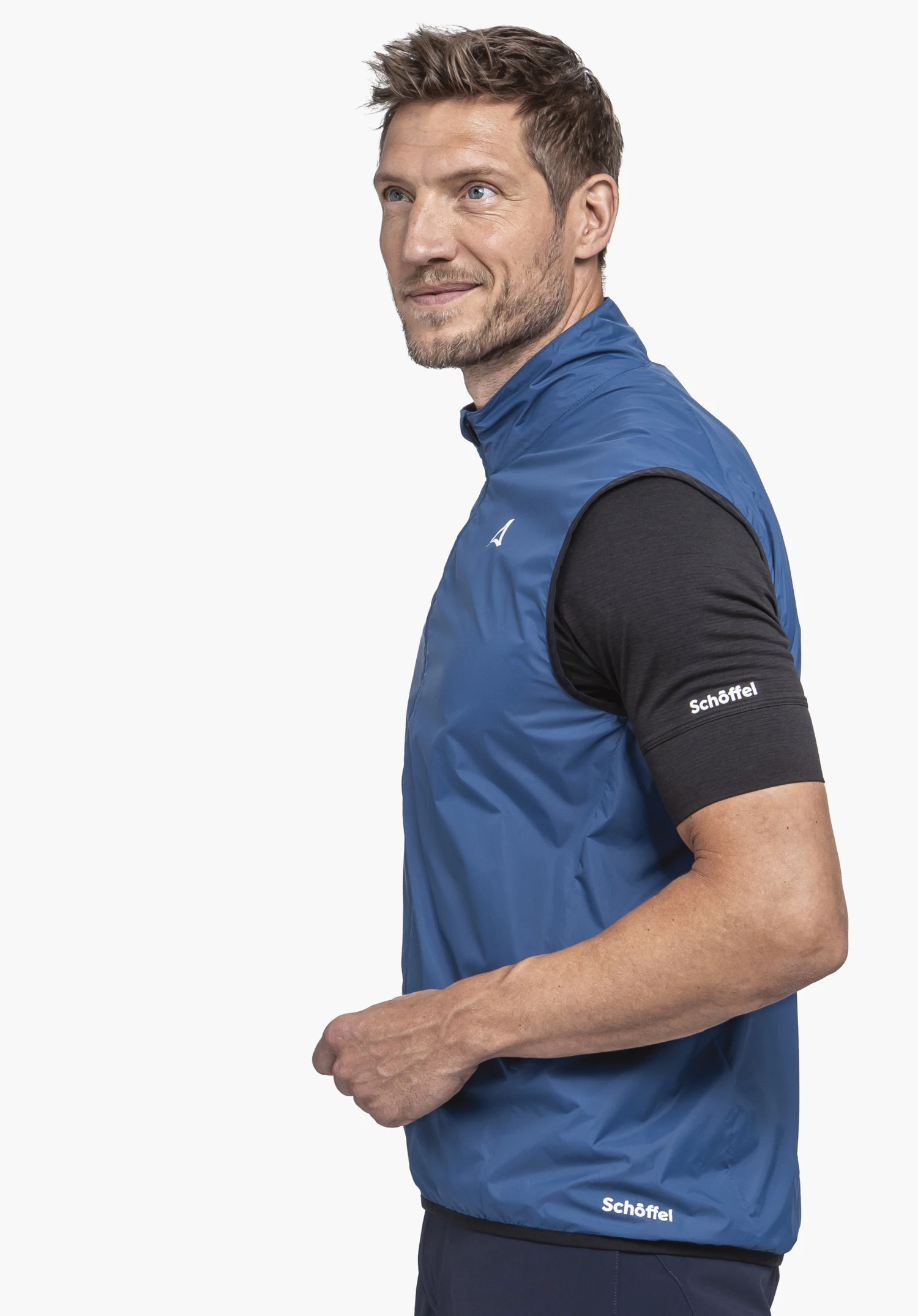 Vest Style Cannobio MNS: A model wears the blue vest while standing sideways against a neutral background; the Schöffel logo is visible on the chest and the bottom hem.
