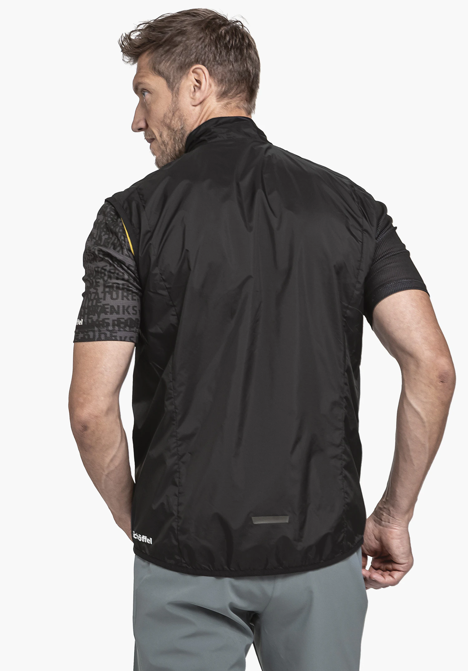 Vest Style Cannobio MNS shown from the back on a model against a neutral background, the black vest features the Schöffel logo at the bottom left.