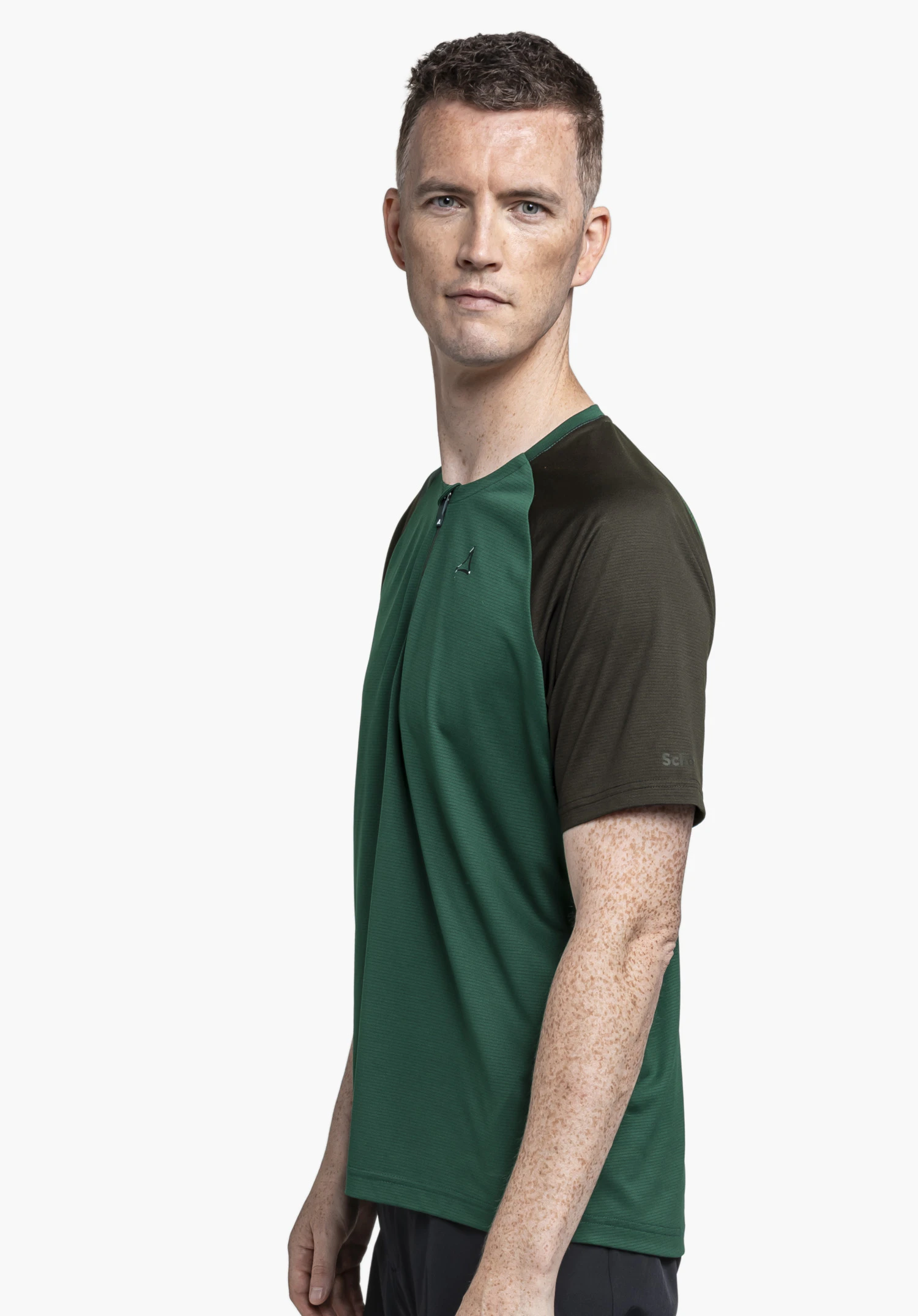 CIRC Shirt Style Wetluga MNS, le t-shirt à manches courtes vert avec col zippé et logo Schöffel visible, porté par un mannequin de profil sur un fond neutre.