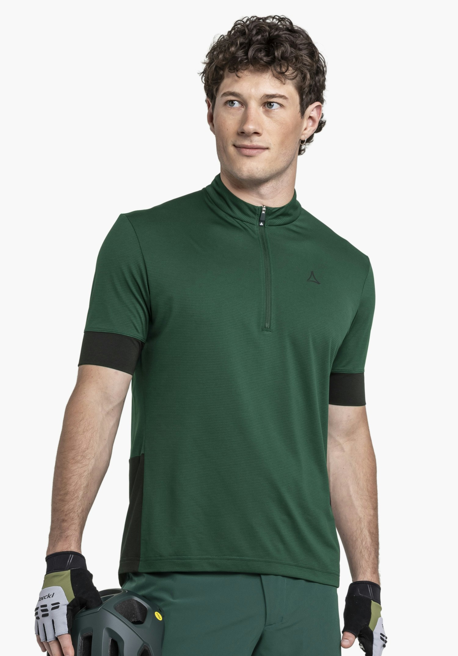 CIRC Shirt Style Pinega MNS in Grün: Ein Model präsentiert das Shirt vor neutralem Hintergrund. Der Träger steht leicht seitlich und blickt in die Ferne, wobei das dezente Schöffel-Logo auf der Brust gut zur Geltung kommt.