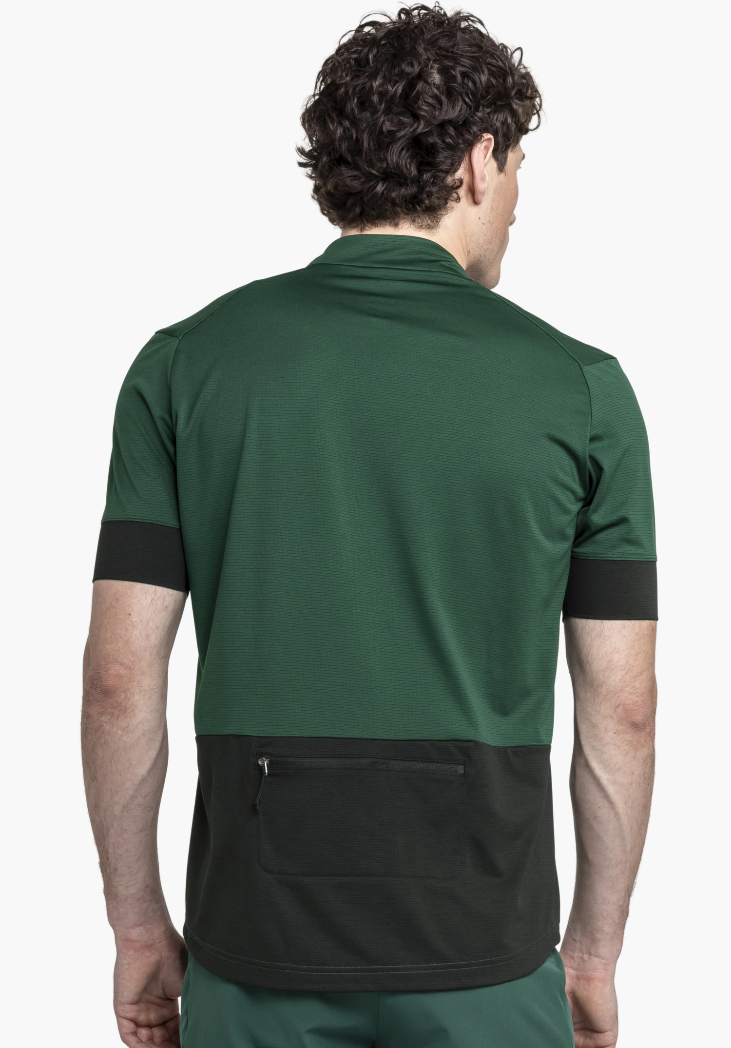 CIRC Shirt Style Pinega MNS shown from the back against a neutral background. The model wears the shirt in a rich green tone with contrasting dark details. The functional zipped back pocket is clearly visible.