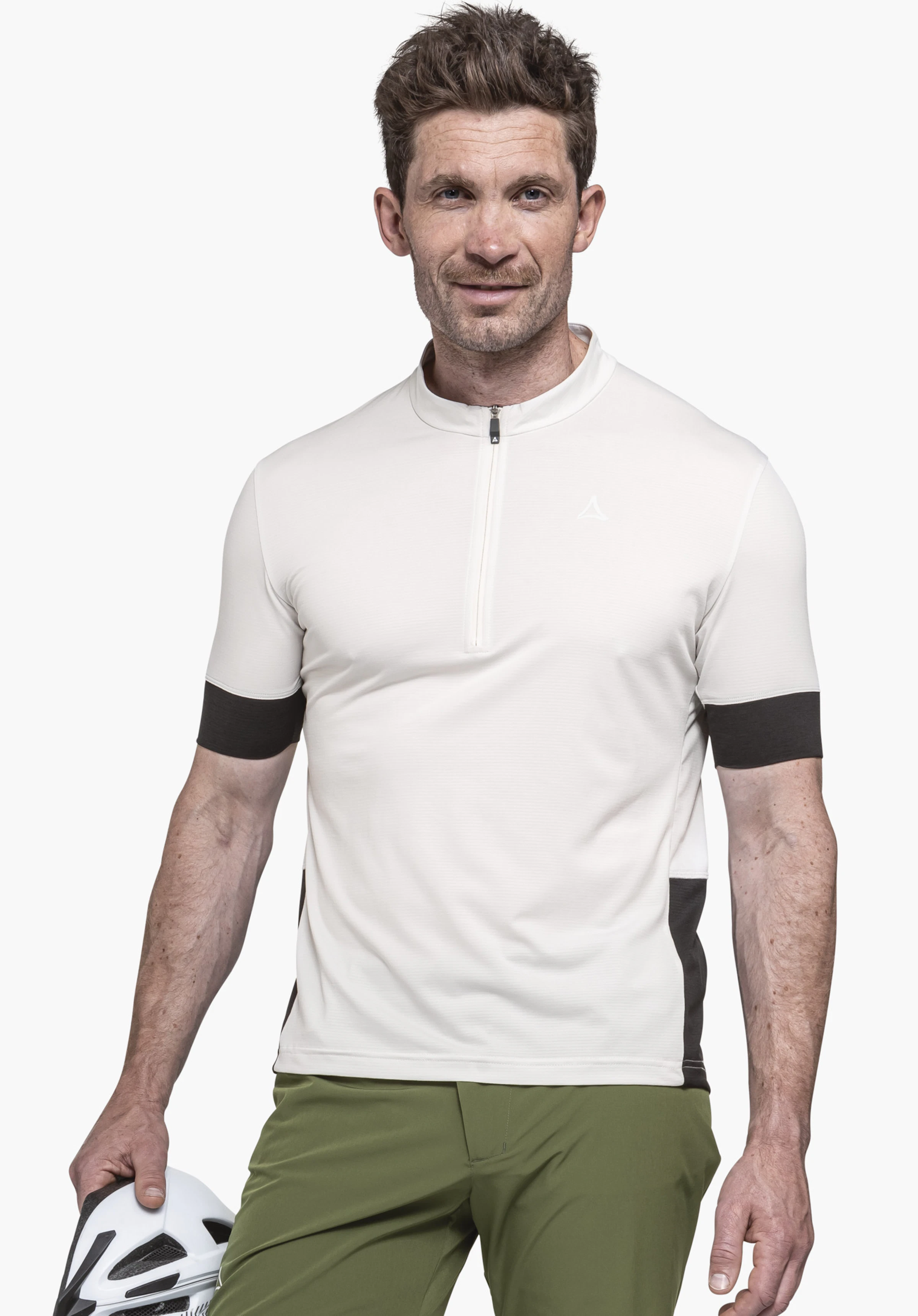 CIRC Shirt Style Pinega MNS man wearing an off-white short-sleeve performance shirt with Schöffel logo; smiling, holding a white and black bicycle helmet, dark green trousers; light neutral background.