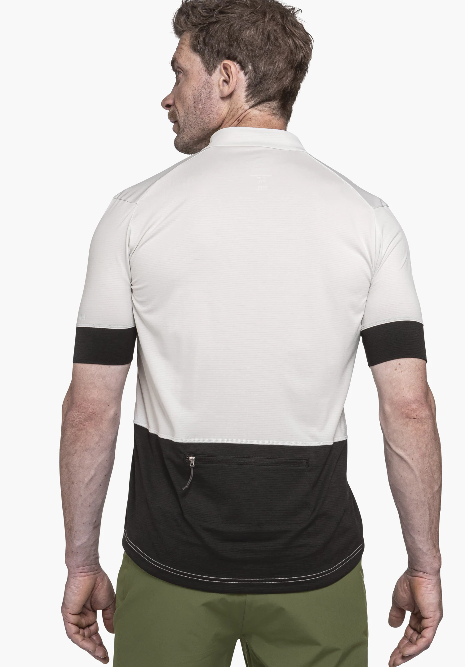 CIRC Shirt Style Pinega MNS off-white T-shirt with black lower panel, black sleeve cuffs and rear zip pocket; worn by a man standing in rear view against a light background; Schöffel logo centred at the upper back.