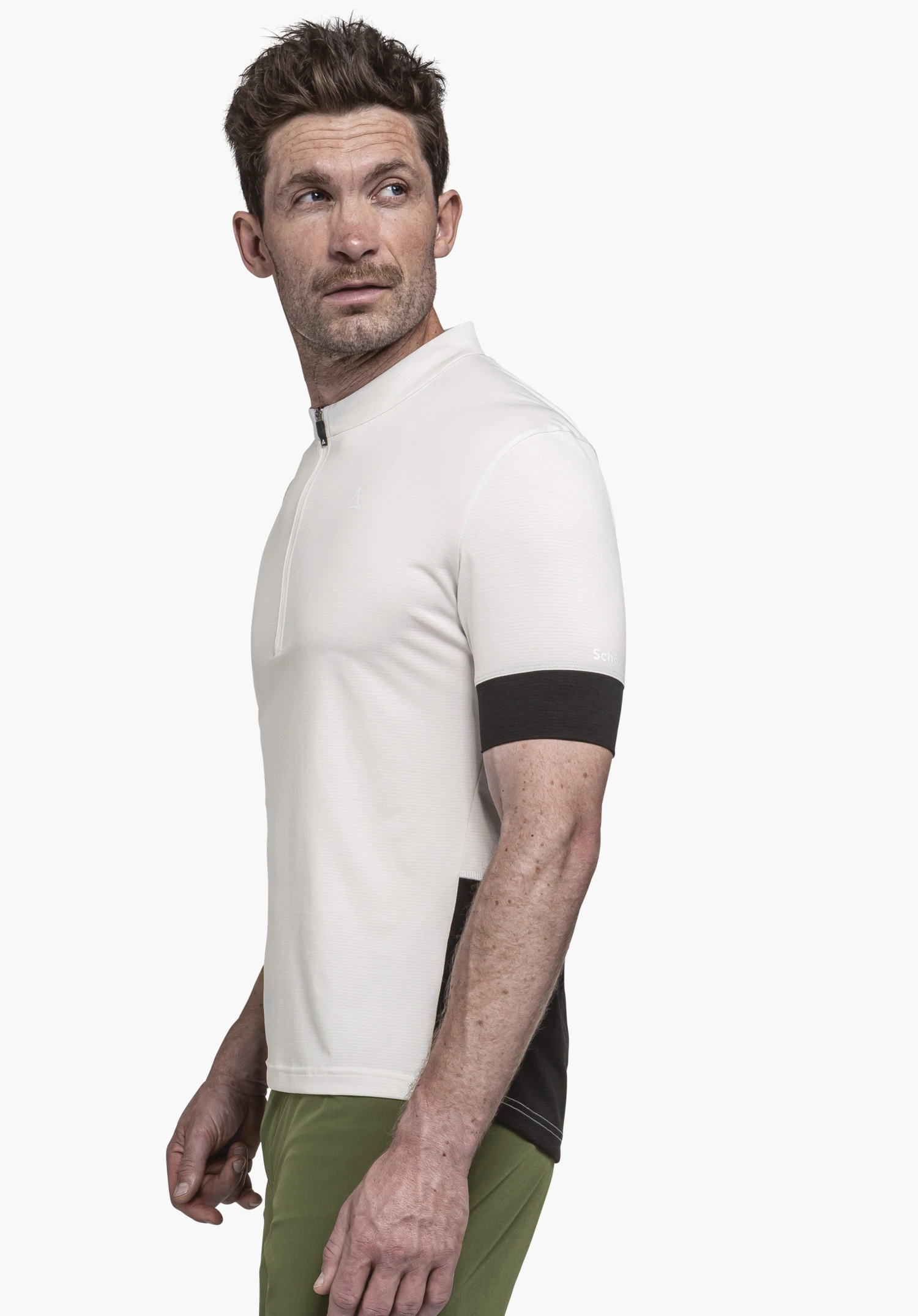 CIRC Shirt Style Pinega MNS white short-sleeve shirt with Schöffel logo; model turns head to the left, stands side-on; black sleeve cuffs, dark green trousers, neutral white background. Text: Schöffel.