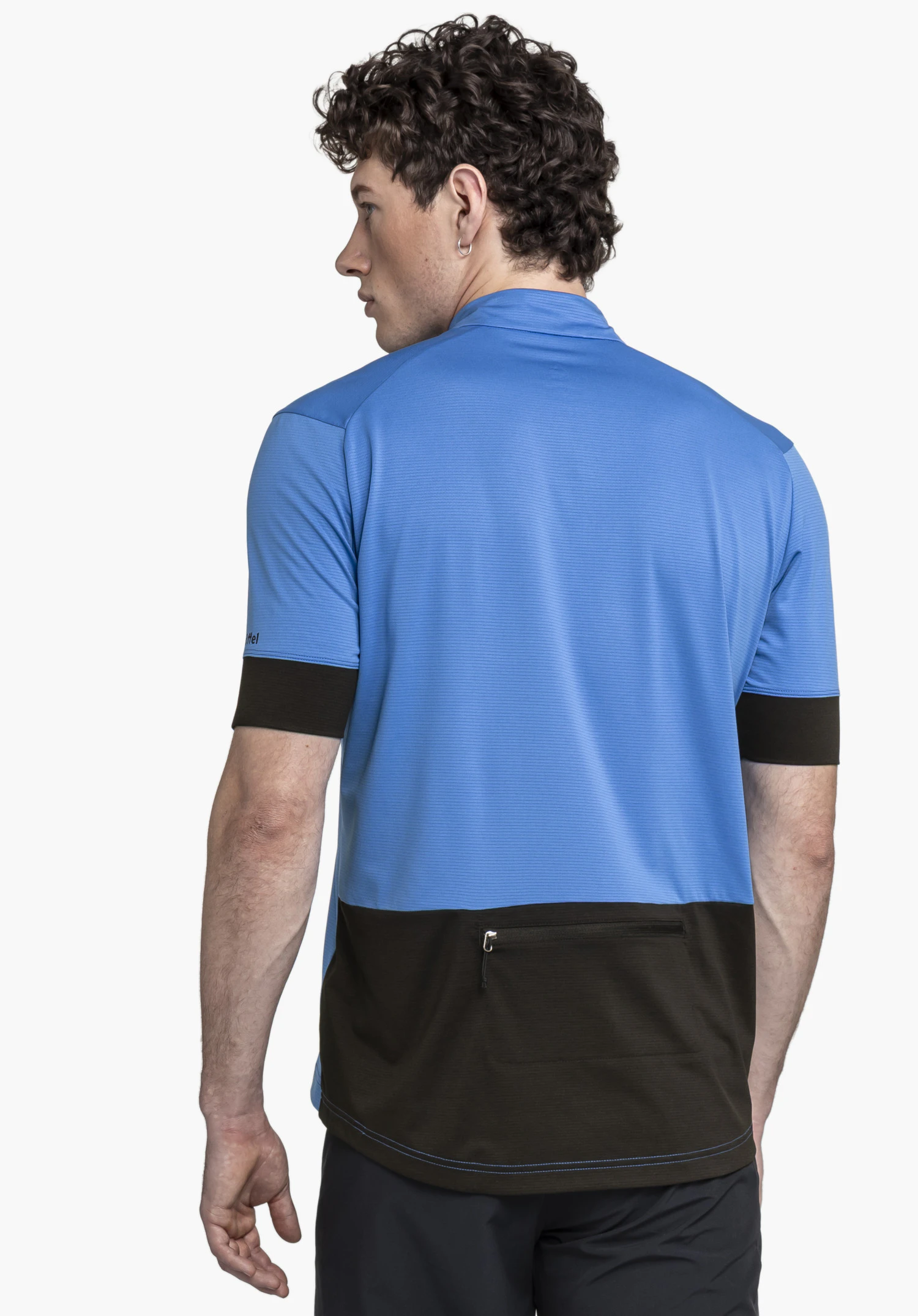 CIRC Shirt Style Pinega MNS en bleu : Un mannequin présente le haut en vue arrière sur un fond neutre. Cette image met en avant la coupe sportive, l'empiècement noir contrastant avec poche zippée dans le dos ainsi que le discret logo Schöffel positionné sur le côté.