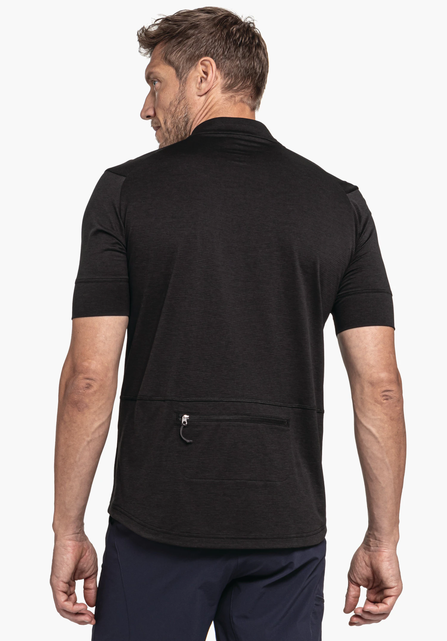 CIRC Shirt Style Pinega MNS in black is shown in a back view against a neutral background. The focus is on the rear side of the shirt featuring a practical zippered pocket, while the model’s head is turned slightly to the side.