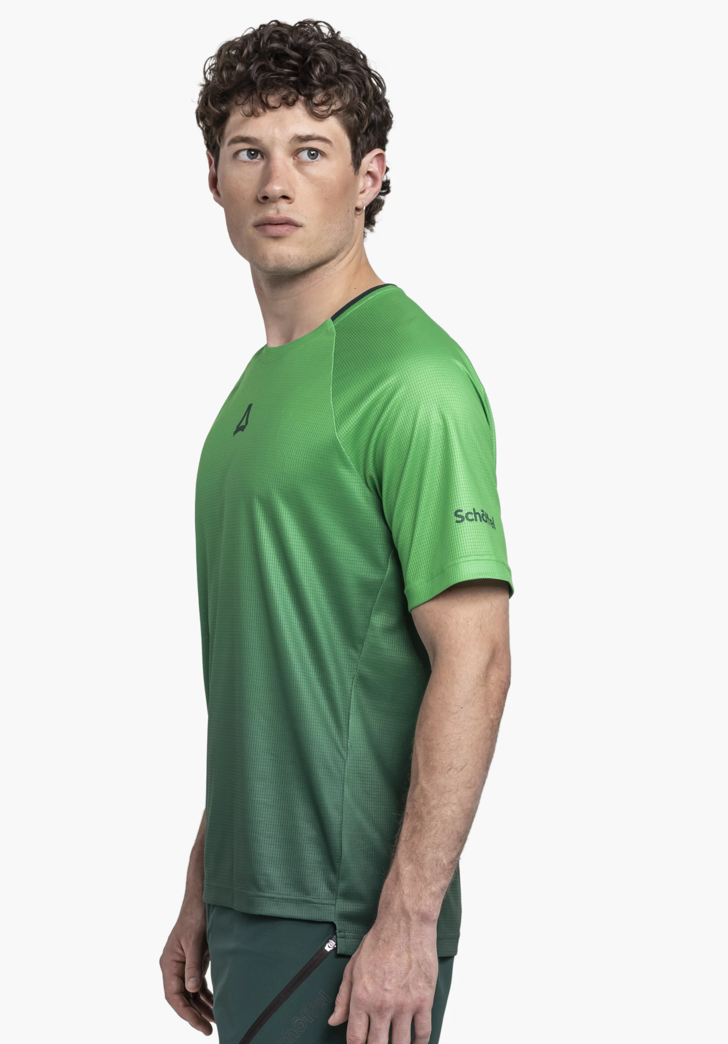 Shirt Style Koitere MEN: A model wearing the green functional shirt is standing sideways against a neutral background; the Schöffel logo is visible on the chest and the sleeve.