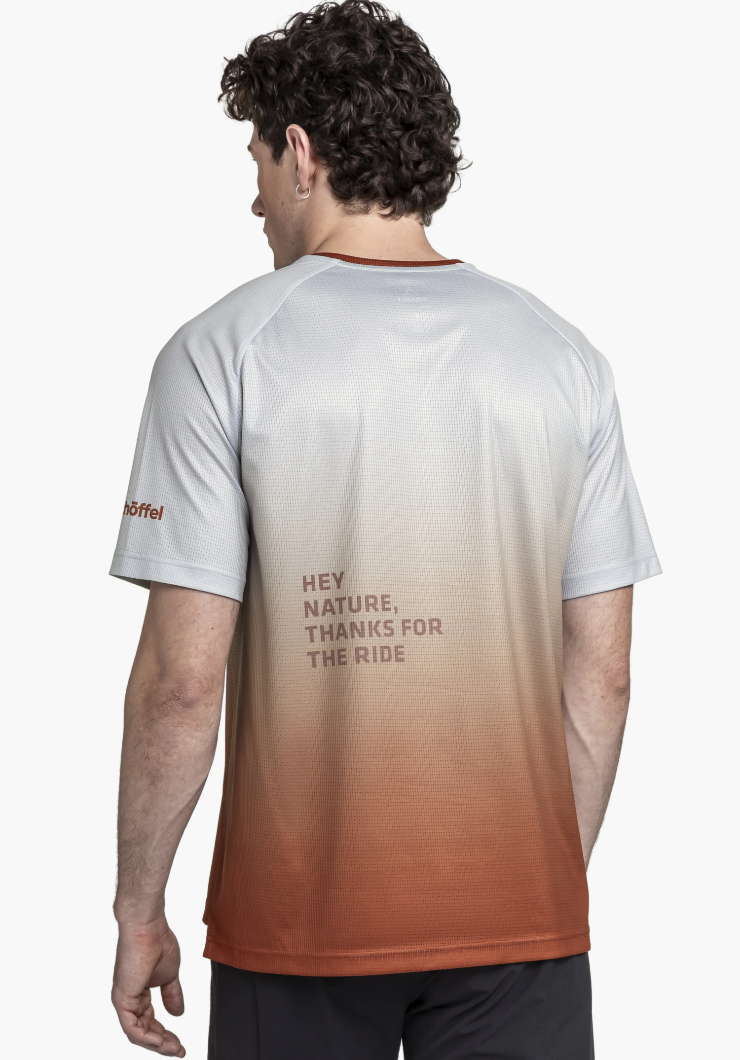 Shirt Style Koitere MEN shown from the back against a neutral background. The model wears the functional shirt with a red gradient, featuring a bold print on the back. The subtle Schöffel logo is visible on the sleeve.