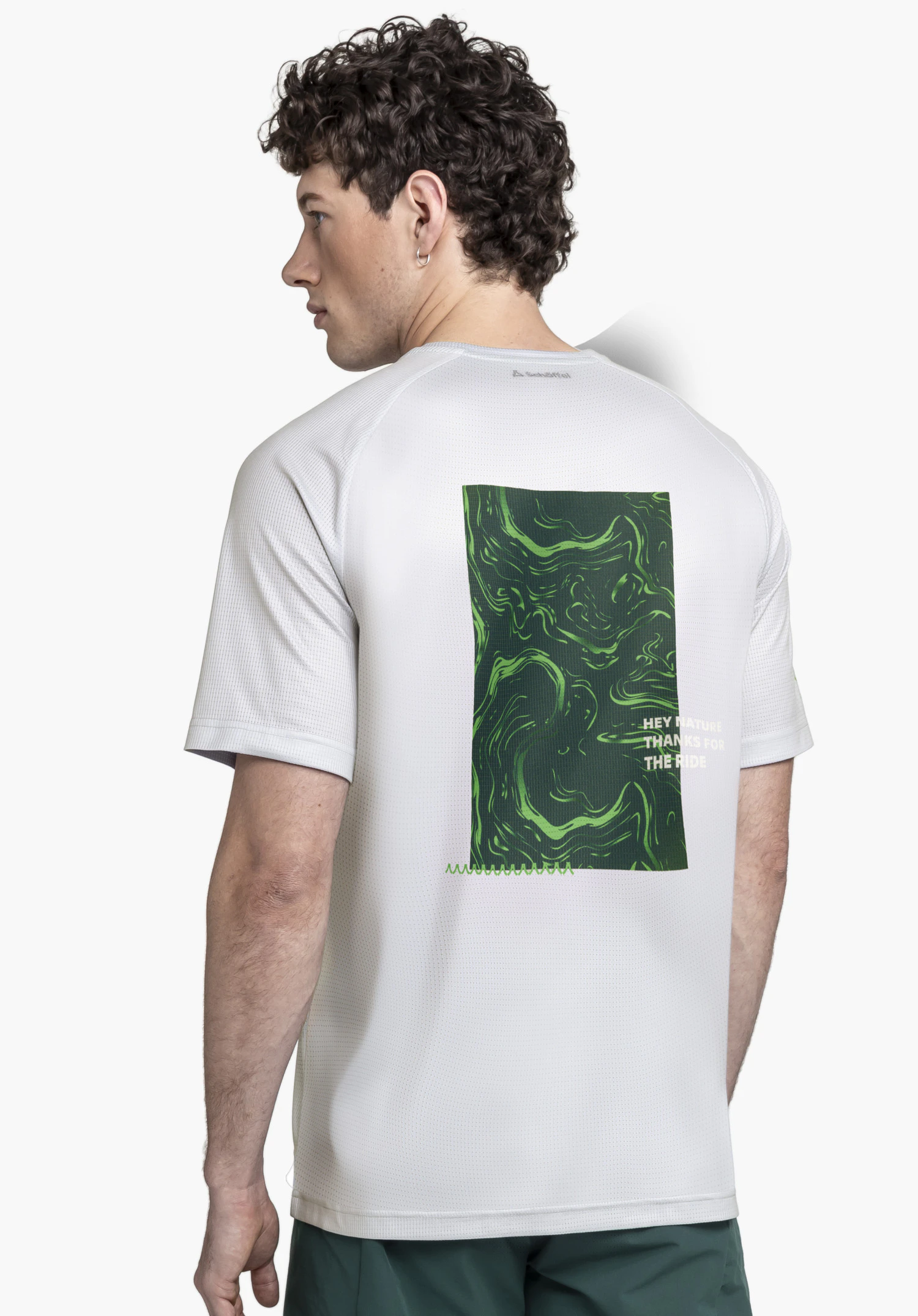 Shirt Style Koitere MEN en gris. Le modèle est photographié de dos, regardant sur le côté, sur un fond neutre. La vue met en avant l'imprimé graphique marquant au dos ainsi que le discret logo Schöffel au niveau de la nuque.