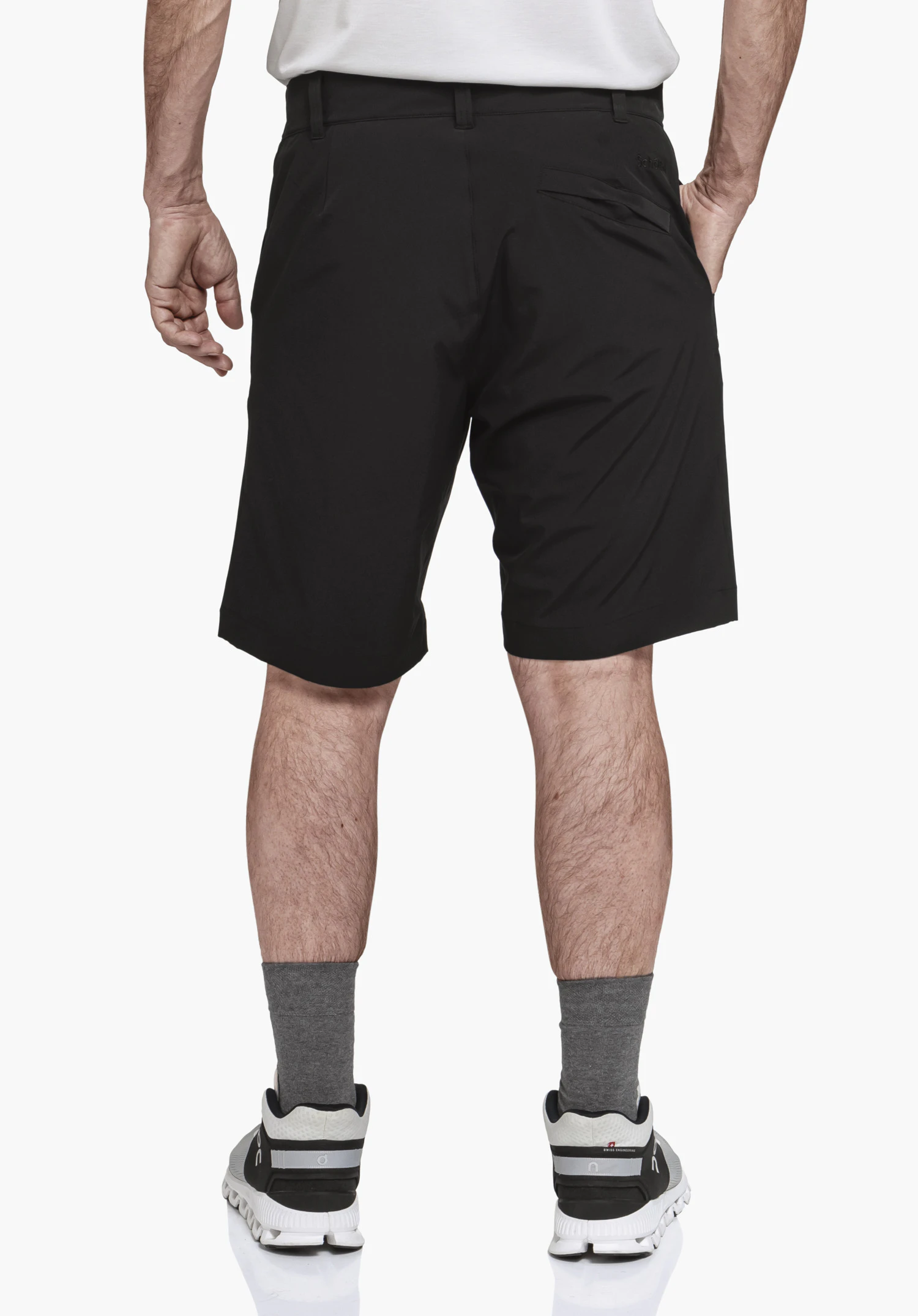 Shorts Style Gharra MNS in der Rückenansicht an einem Model vor neutralem Hintergrund. Die schwarze Shorts zeigt eine Gesäßtasche mit dezentem Schöffel-Logo.