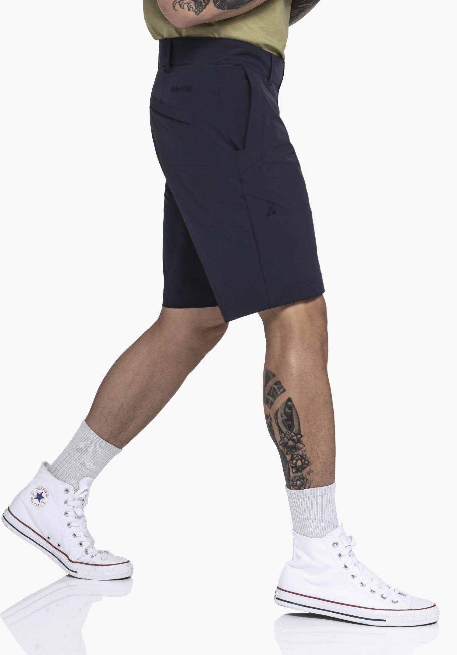 Shorts Style Gharra MNS in blue. The male model stands sideways against a neutral background, showcasing the shorts in a dynamic pose. The subtle Schöffel logo is visible just below the waistband.