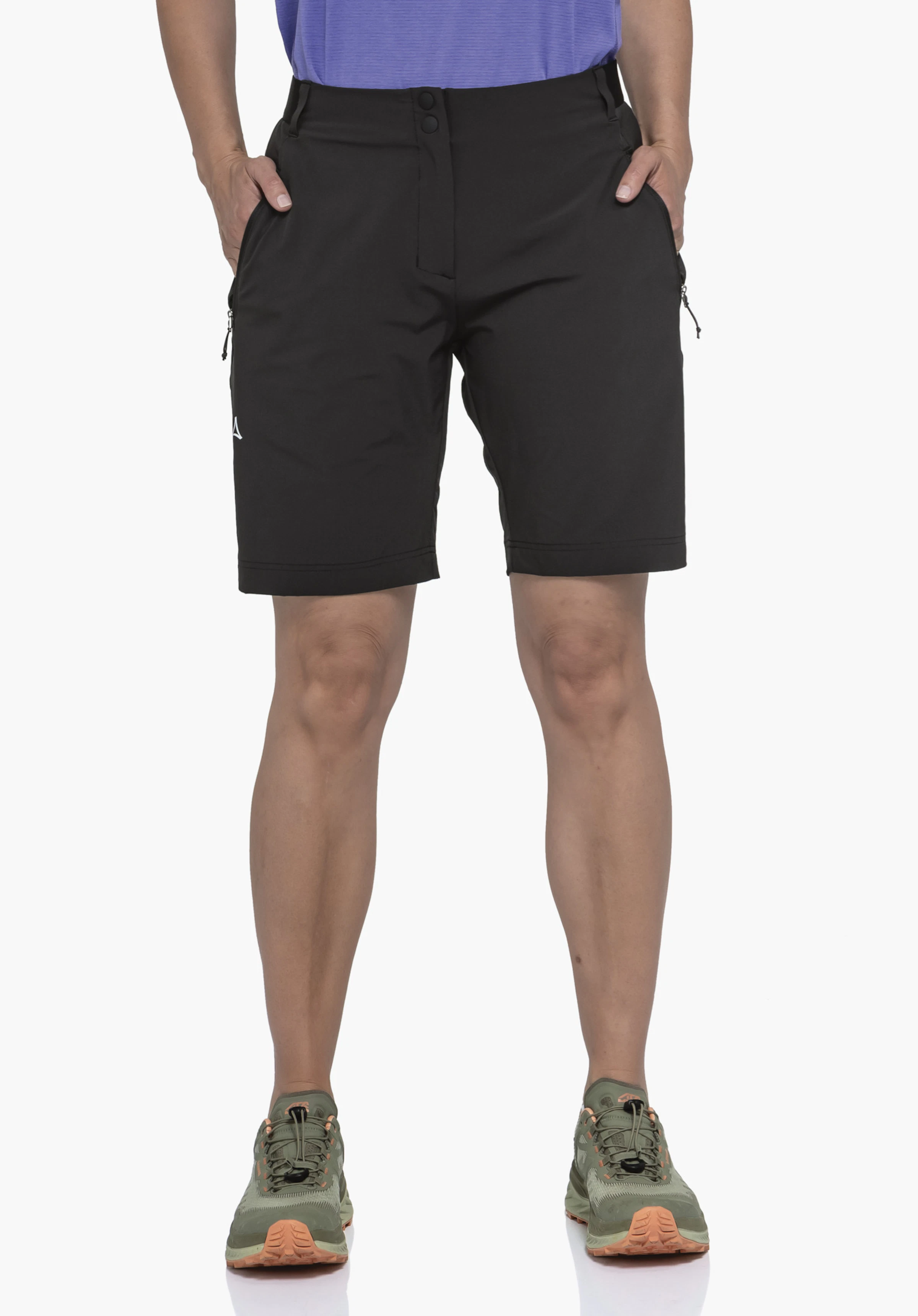 Shorts Style Blaustein WMS de couleur noire, porté par un mannequin. Le mannequin se tient de face avec les mains dans les poches devant un fond neutre. Le logo Schöffel est visible sur la jambe droite.