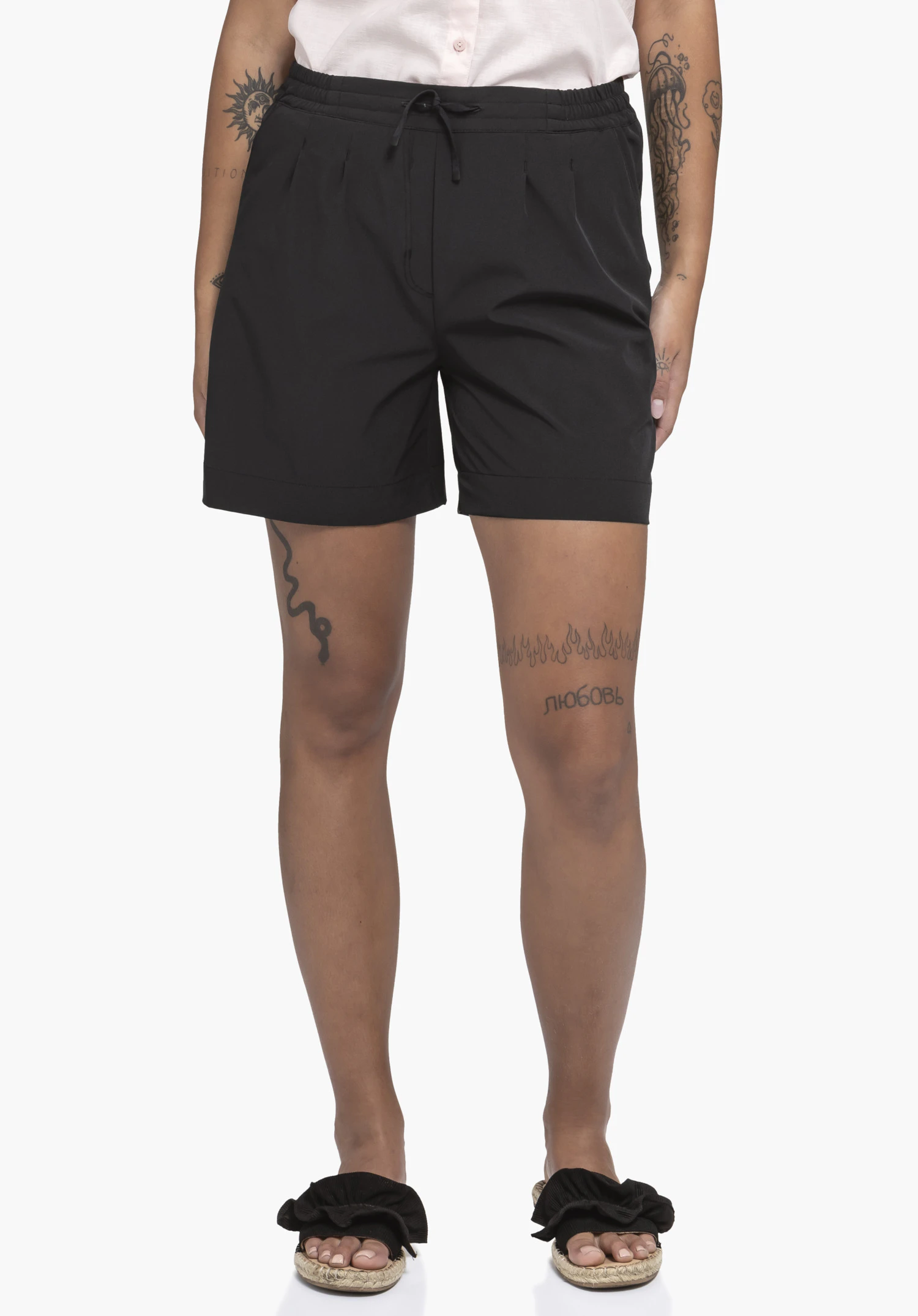Shorts Style Gharra WMS in Schwarz an einem Model. Das Model steht in Frontalansicht vor einem neutralen Hintergrund.