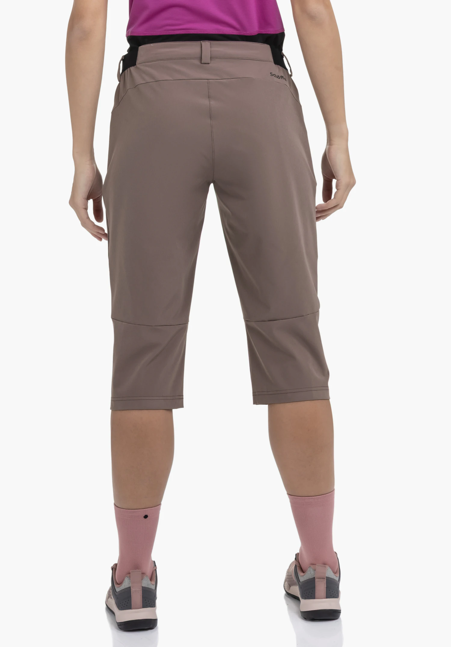 Capri Pants Style Keitele WMS in brown, worn by a model in a back view with the Schöffel logo visible on the right rear below the waistband, photographed against a neutral background.