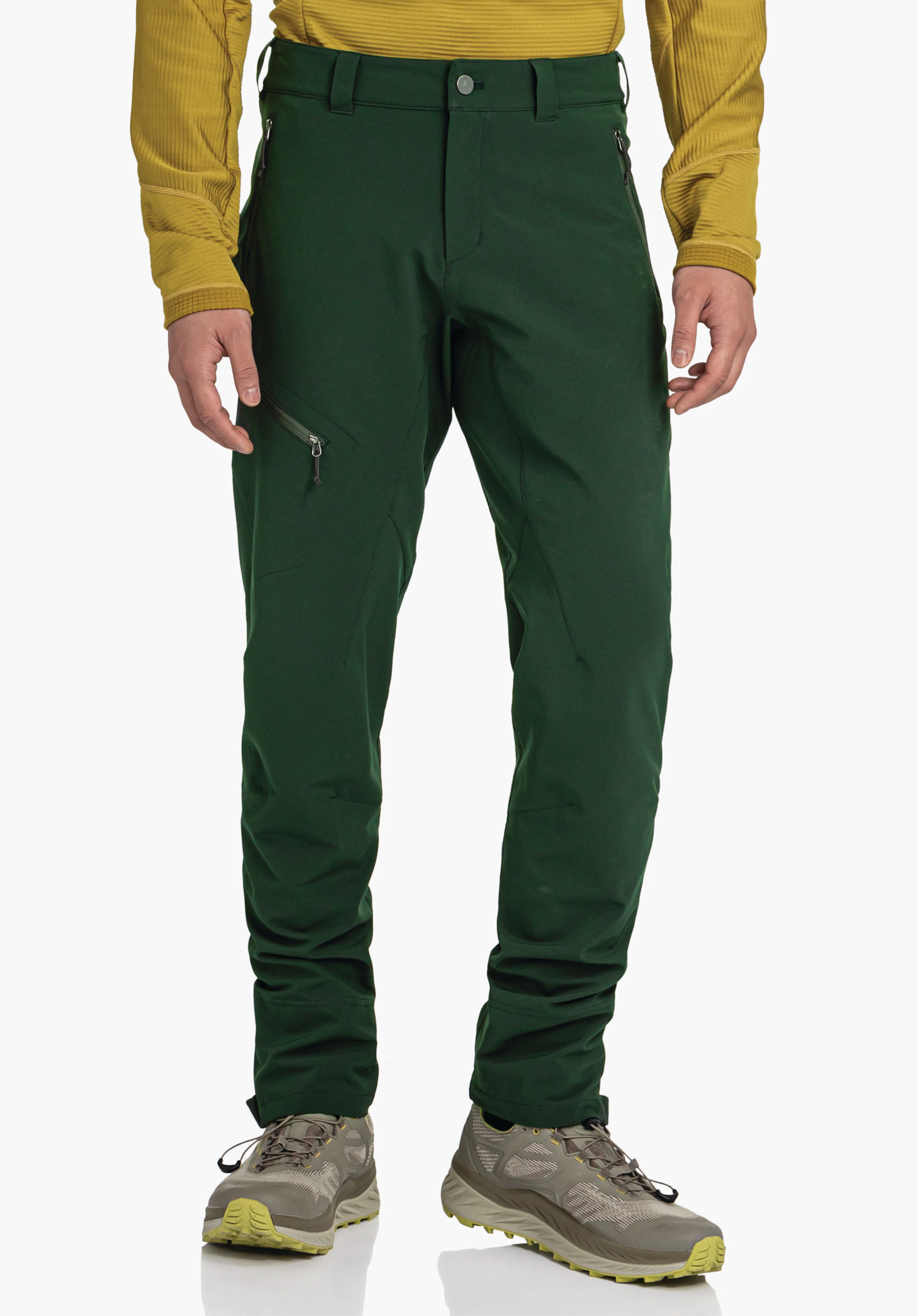 Pants Style Cascata MNS Dark green outdoor trousers with side zip pocket, worn by a standing person in a light yellow top, against a neutral light background.