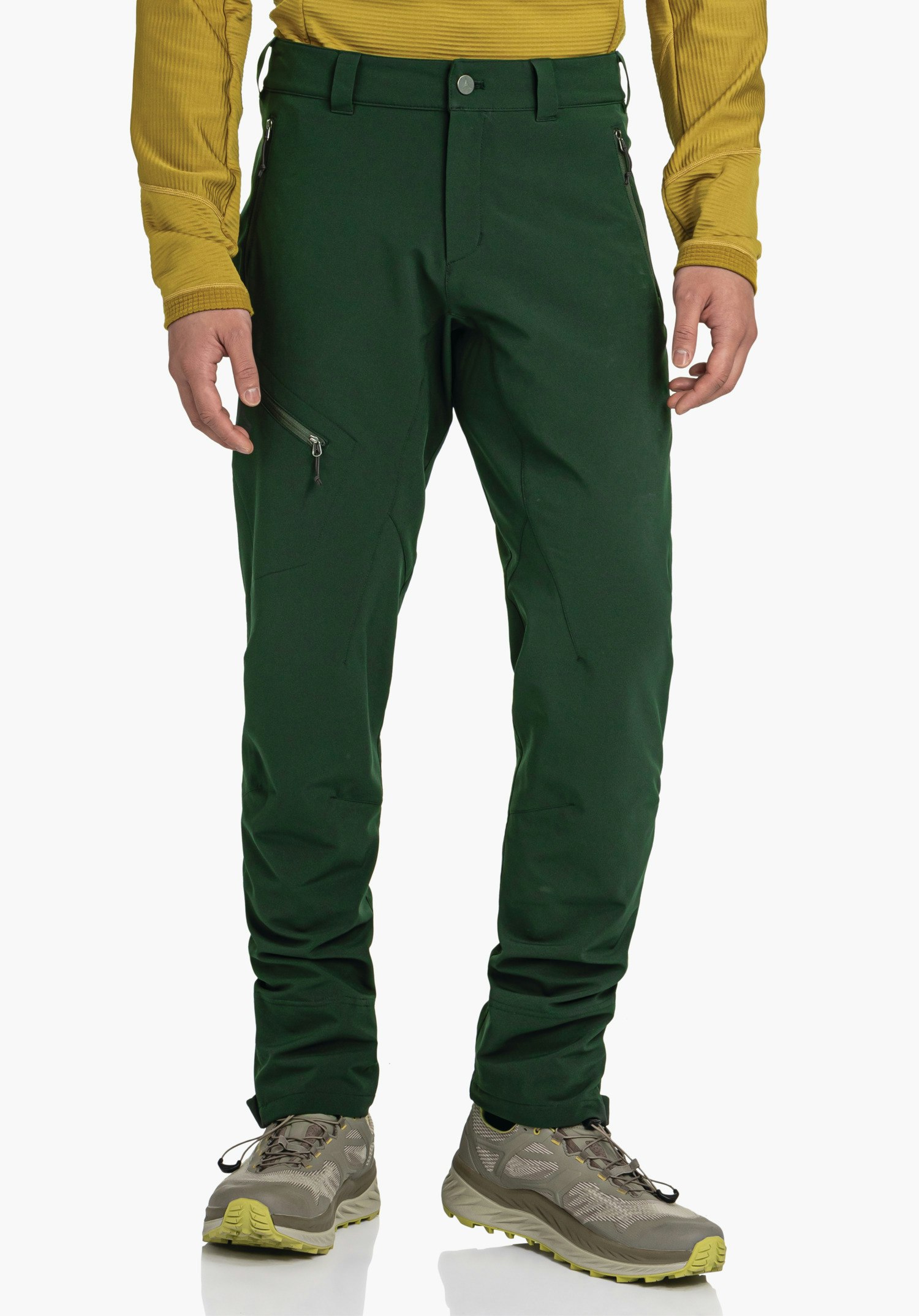 Pants Style Cascata MNS Dark green outdoor trousers with side zip pocket, worn by a standing person in a light yellow top, against a neutral light background.