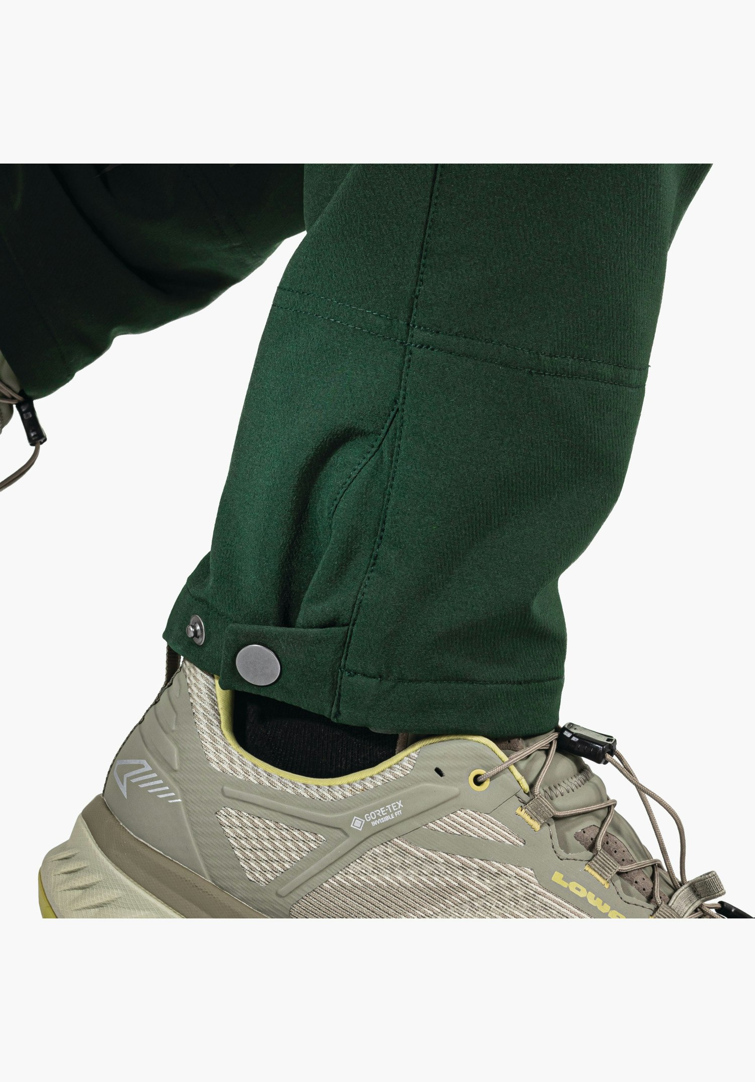 Pants Style Cascata MNS, adjustable leg hem with silver press stud on the green fabric, close-up against a white background.