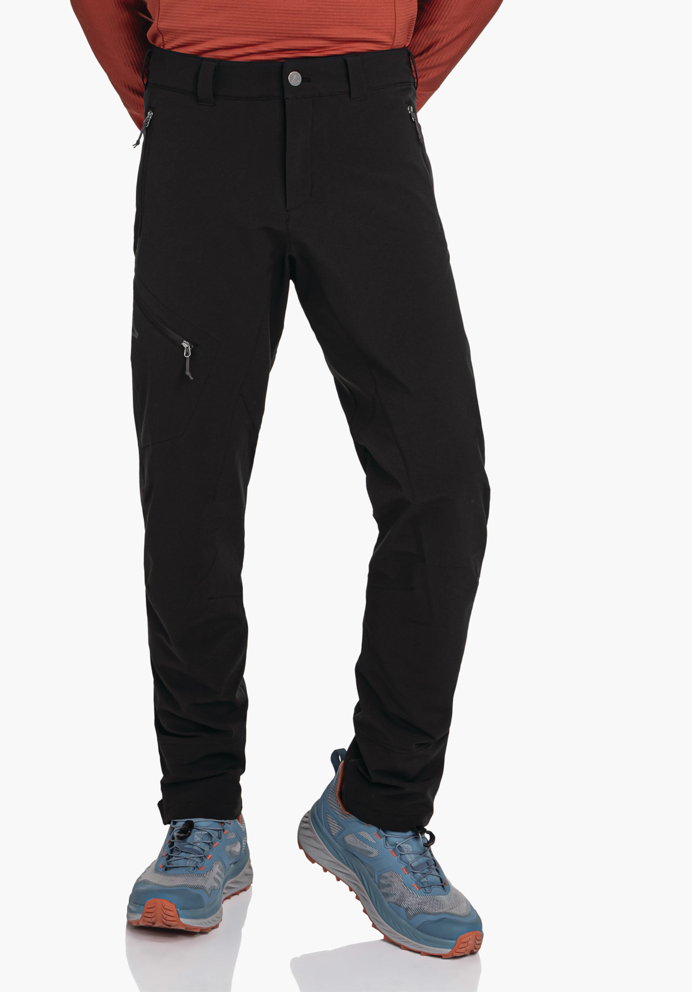 Pants Style Cascata MNS Black trousers worn by a standing person, legs slightly apart; dark red top visible, light blue shoes with orange sole, Schöffel logo on left thigh, light background.