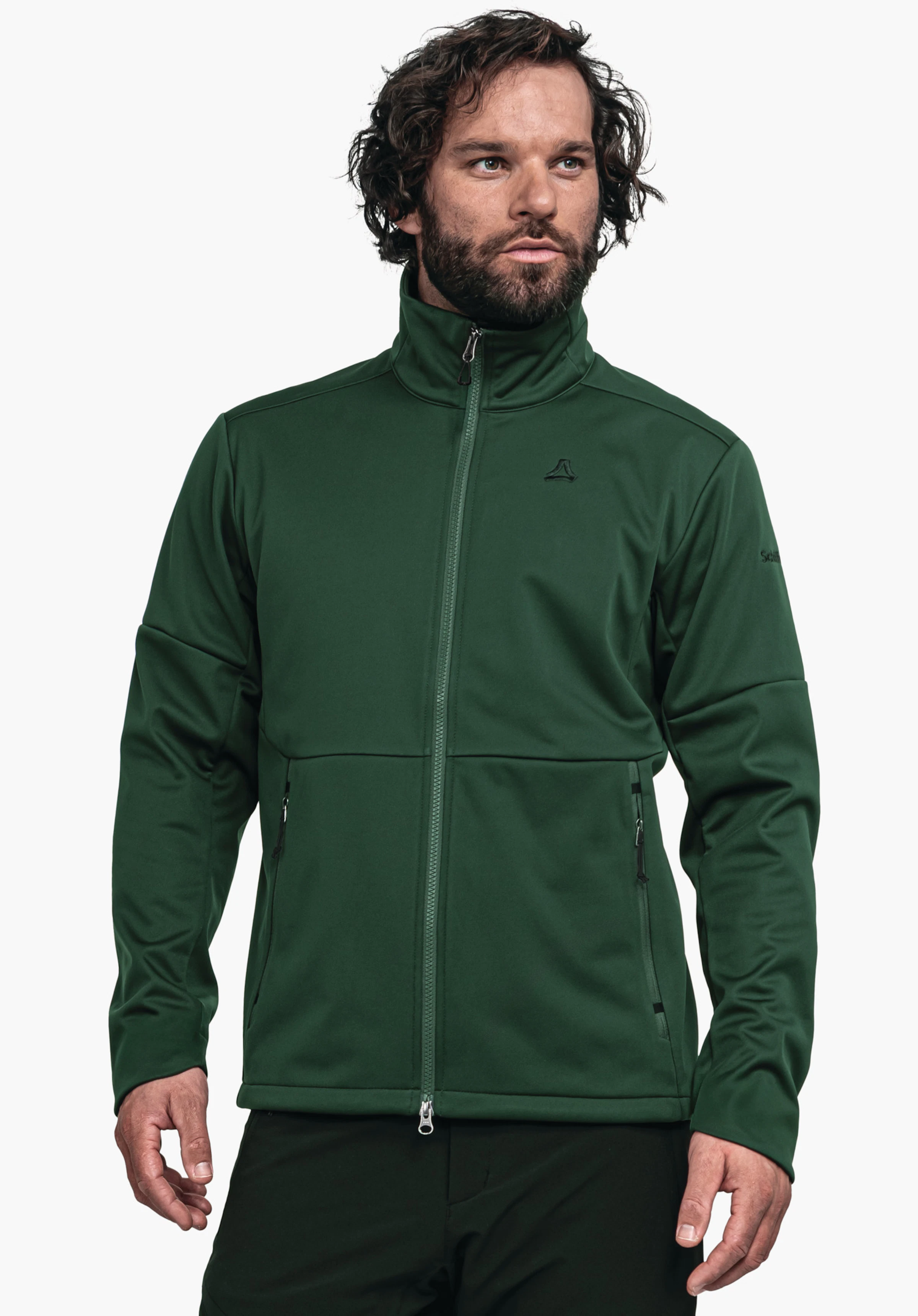 Softshell Jk Style Fracon MNS dunkelgrüne Jacke, getragen von einem stehenden Mann, der nach rechts blickt; Reißverschluss geschlossen; Schöffel-Logo auf Brust; Text auf Ärmel: "Schöffel"; neutraler weißer Hintergrund.