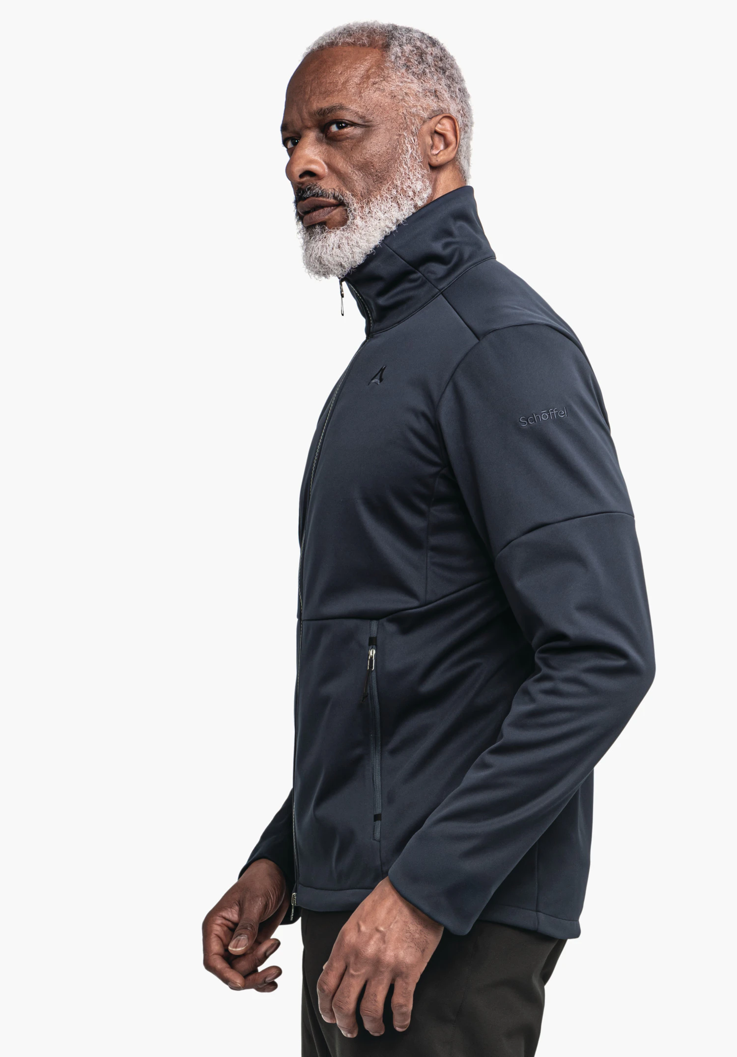 Softshell Jk Style Fracon MNS man wears a dark blue jacket with Schöffel logo, stands side-on and looks forward, light white background. Text in image: "Schöffel".