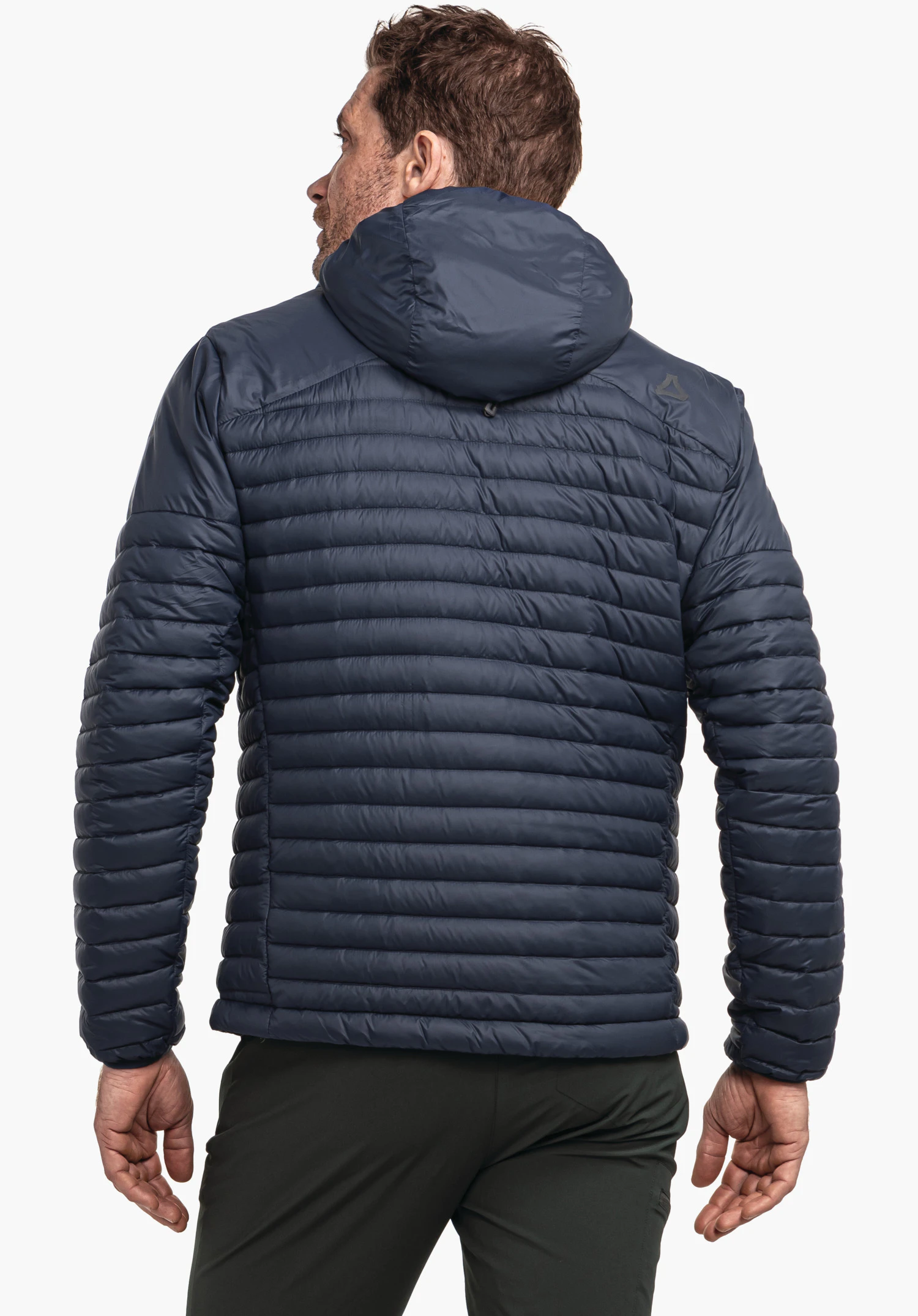 Down Jacket Style Cascata MNS Dunkelblaue, gesteppte Kapuzenjacke (Schöffel-Logo auf rechter Schulter) wird rückwärts getragen; Mann steht vor neutralem weißem Hintergrund.