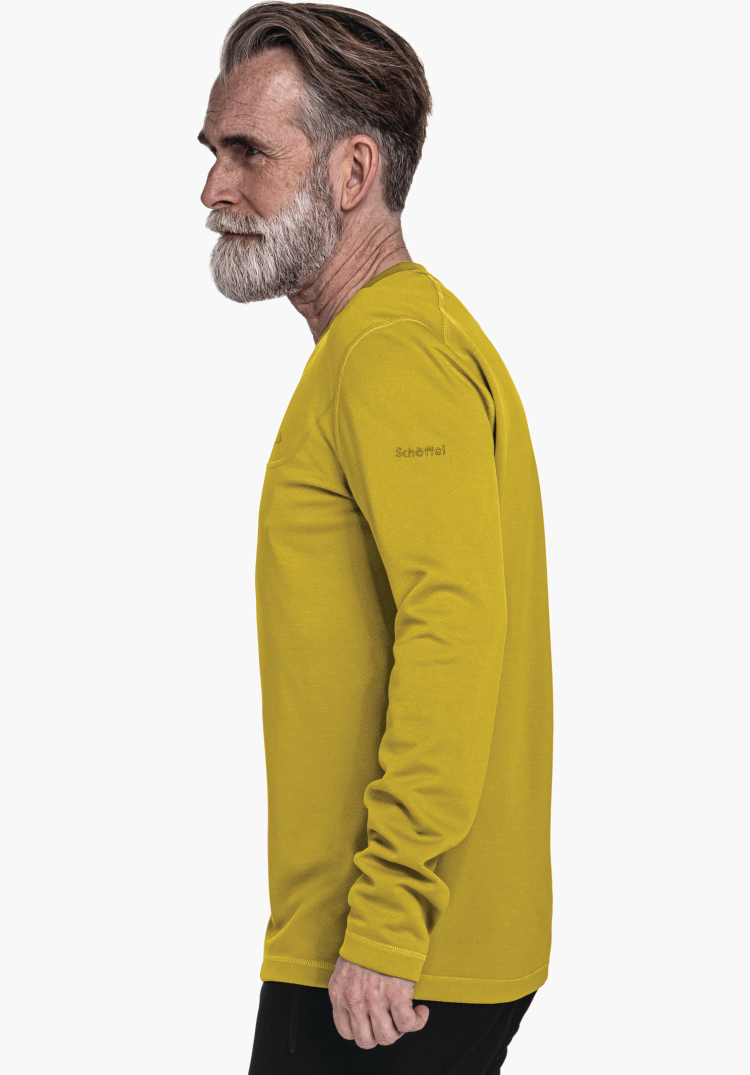CIRC Longsleeve Style Smue MNS haut manches longues jaune foncé porté par un homme debout de profil, regard vers l’avant; fond blanc neutre. Texte sur la manche: "Schöffel".