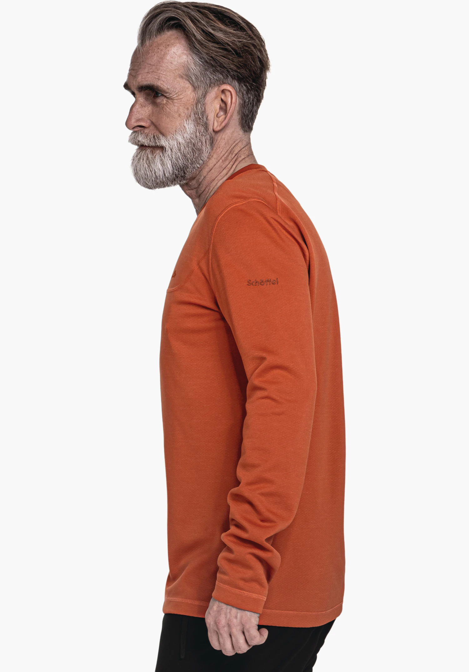 CIRC Longsleeve Style Smue MNS homme en haut manches longues orange foncé, debout de profil et regardant vers la gauche devant un fond clair. Texte sur la manche: "Schöffel".