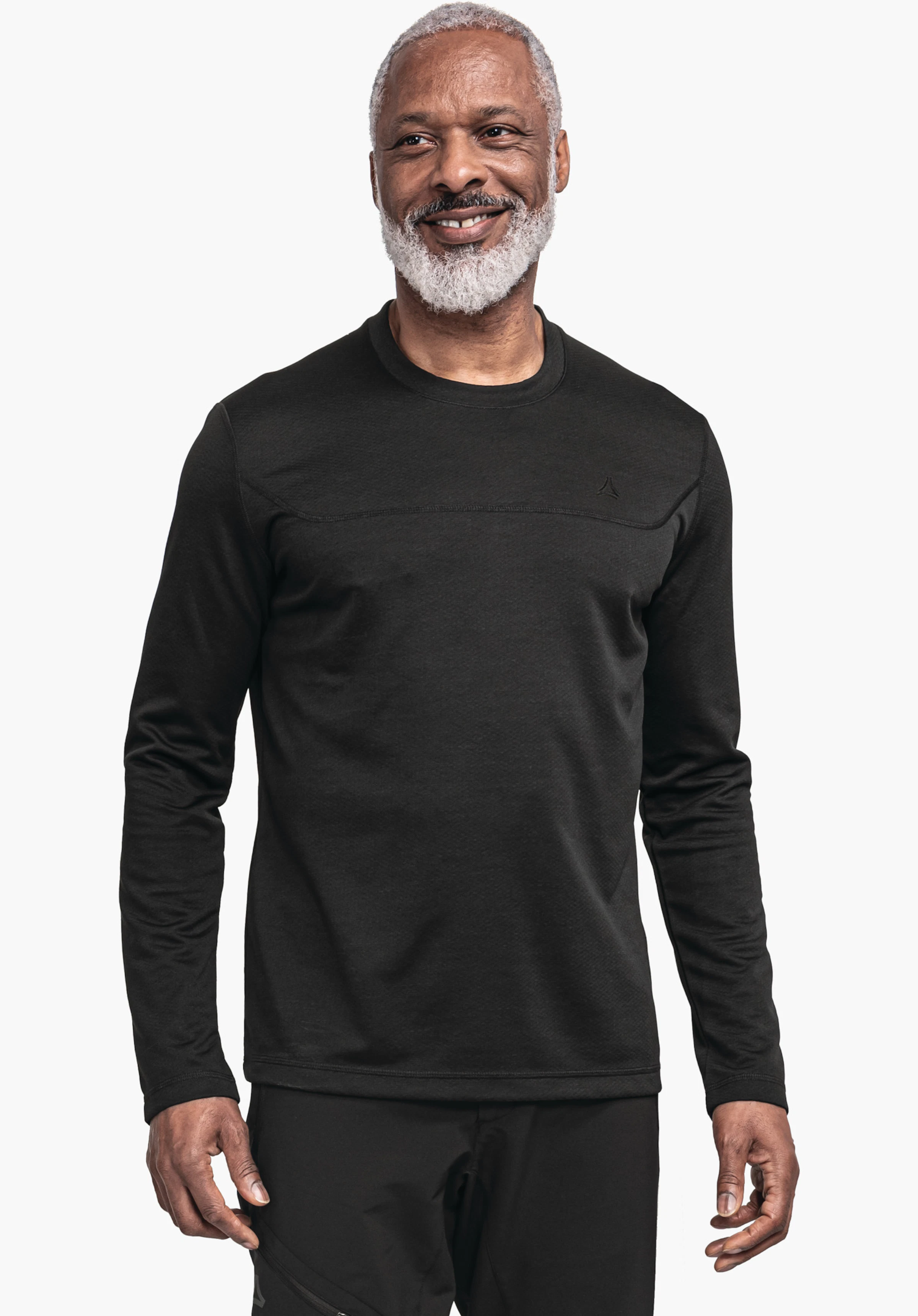 CIRC Longsleeve Style Smue MNS haut à manches longues noir, porté par un homme souriant, mains détendues; logo Schöffel sur la poitrine, fond blanc neutre.