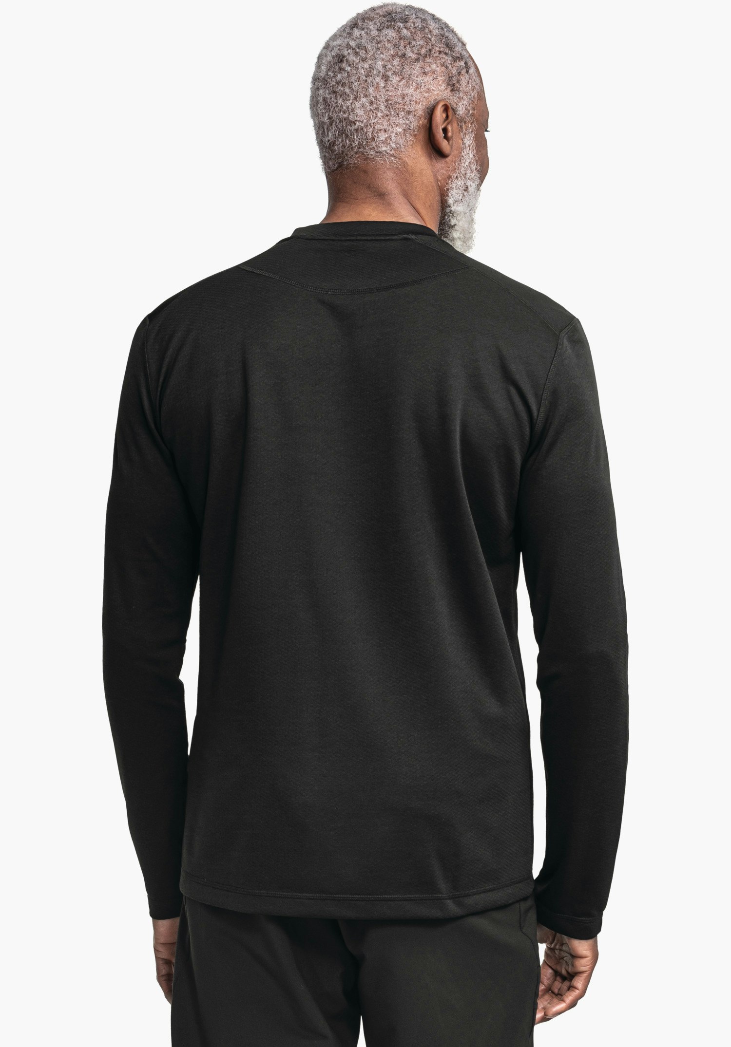 CIRC Longsleeve Style Smue MNS Schwarzes Langarmshirt, getragen von einer Person mit hellgrauen Haaren, steht mit dem Rücken zur Kamera vor weißem Hintergrund; sichtbar Ärmel, Saum und schwarze Hosen.