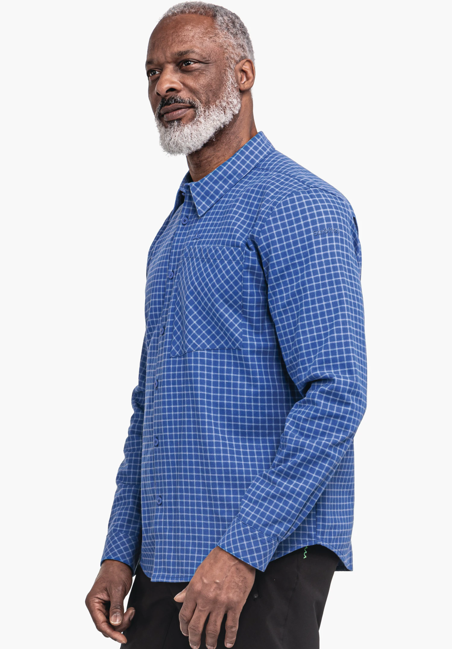 Shirt Style Boyoma MNS Kariertes dunkelblaues Hemd an einem Mann; er steht seitlich und blickt nach links, rechte Hand locker an der Seite, vor einfarbig weißem Hintergrund.