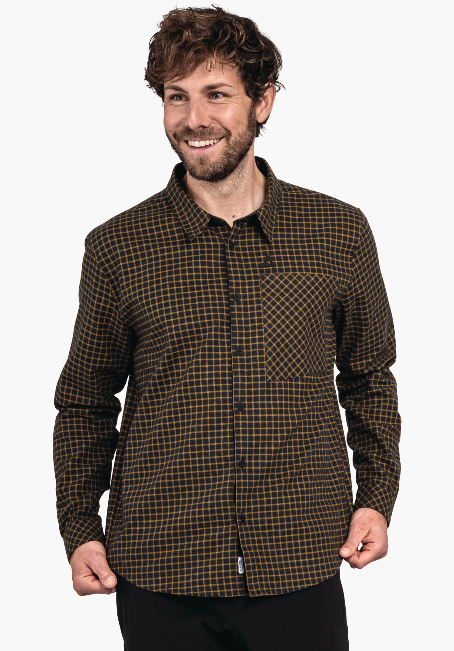 Shirt Style Boyoma MNS chemise à carreaux noire avec lignes jaune clair, portée par un homme souriant; logo Schöffel sur la poche poitrine; fond blanc.
