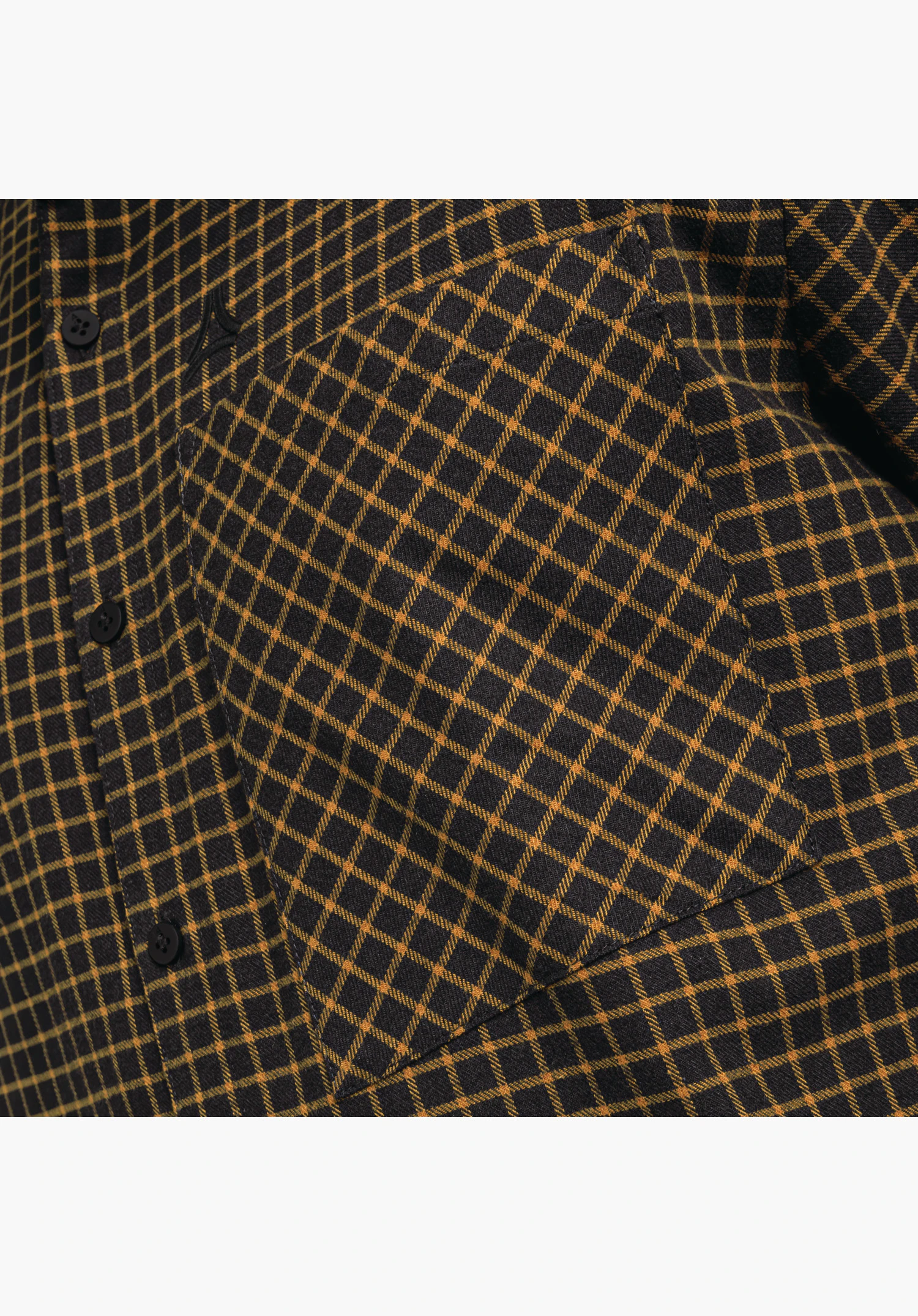 Shirt Style Boyoma MNS – Detailansicht der Brusttasche mit diagonalem Karomuster auf dem schwarzen Stoff, der Knopfleiste und dem gestickten Schöffel-Logo als Nahaufnahme vor weißem/neutralem Hintergrund.