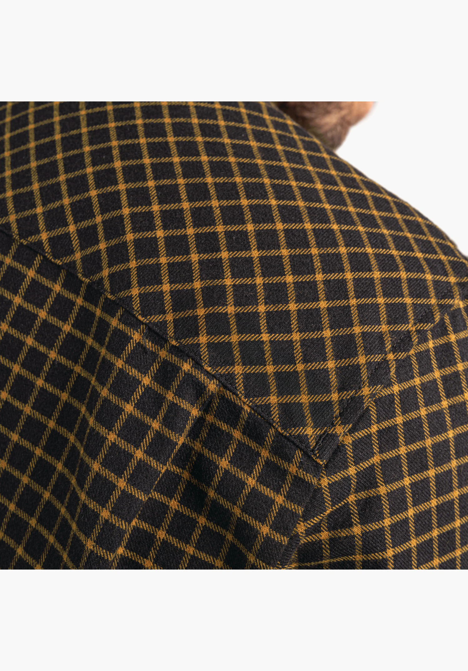Shirt Style Boyoma MNS zeigt das gewebte Karomuster in Schwarz mit gelben Akzenten im Schulterbereich. Nahaufnahme vor weißem/neutralem Hintergrund.