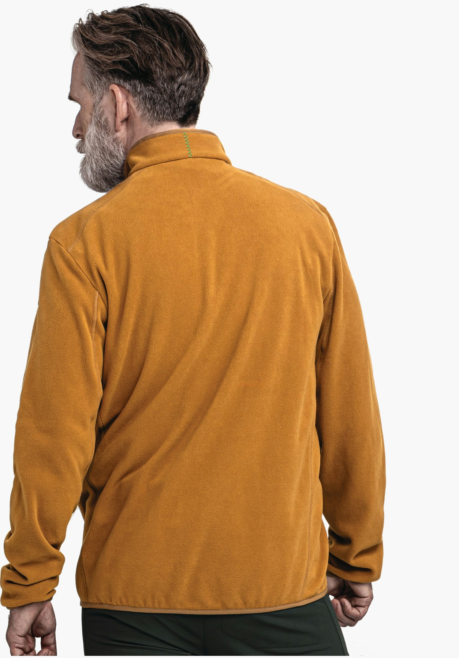 Fleece Jk Style Ash MNS Fleecejacke: Mann trägt dunkelgelbe Jacke, steht mit Rücken zur Kamera, Kopf seitlich gewendet; grüne Naht am Kragen, dunkelgrüne Hosen, weißer Studiohintergrund.