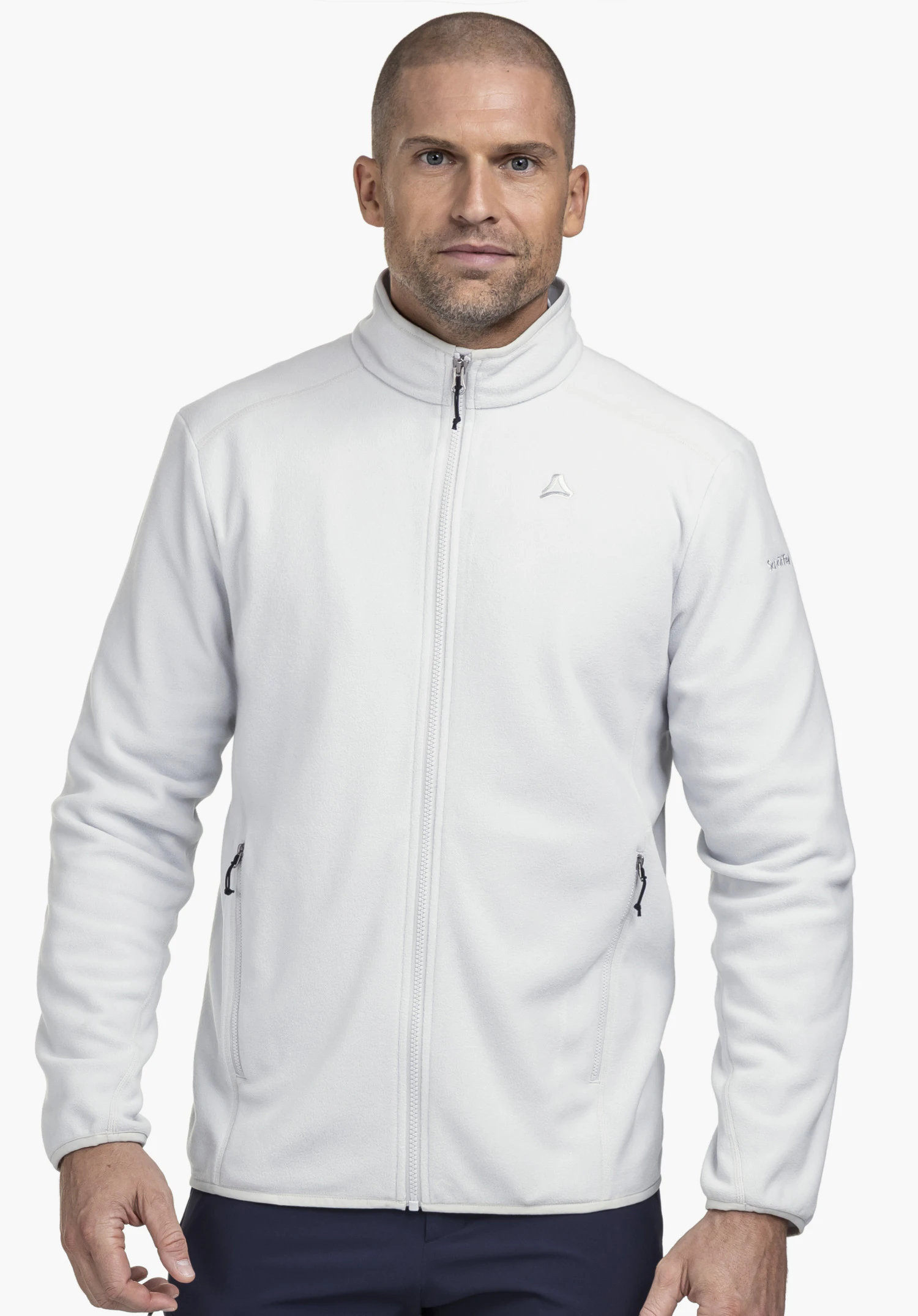 Fleece Jk Style Ash MNS on a model standing frontally. The grey fleece jacket is zipped up and shows the Schöffel logo on the left chest in front of a neutral background.