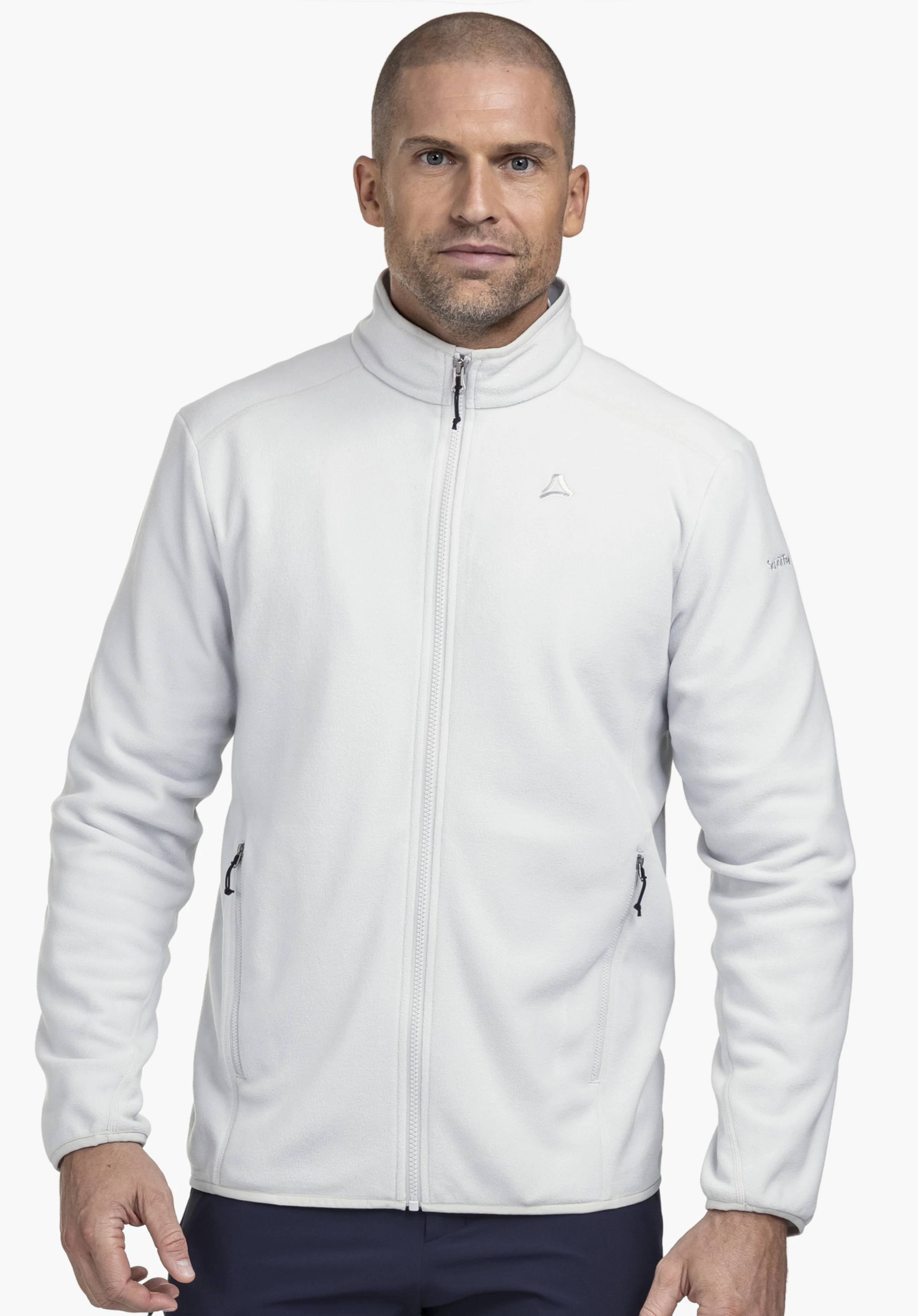 Fleece Jk Style Ash MNS on a model standing frontally. The grey fleece jacket is zipped up and shows the Schöffel logo on the left chest in front of a neutral background.