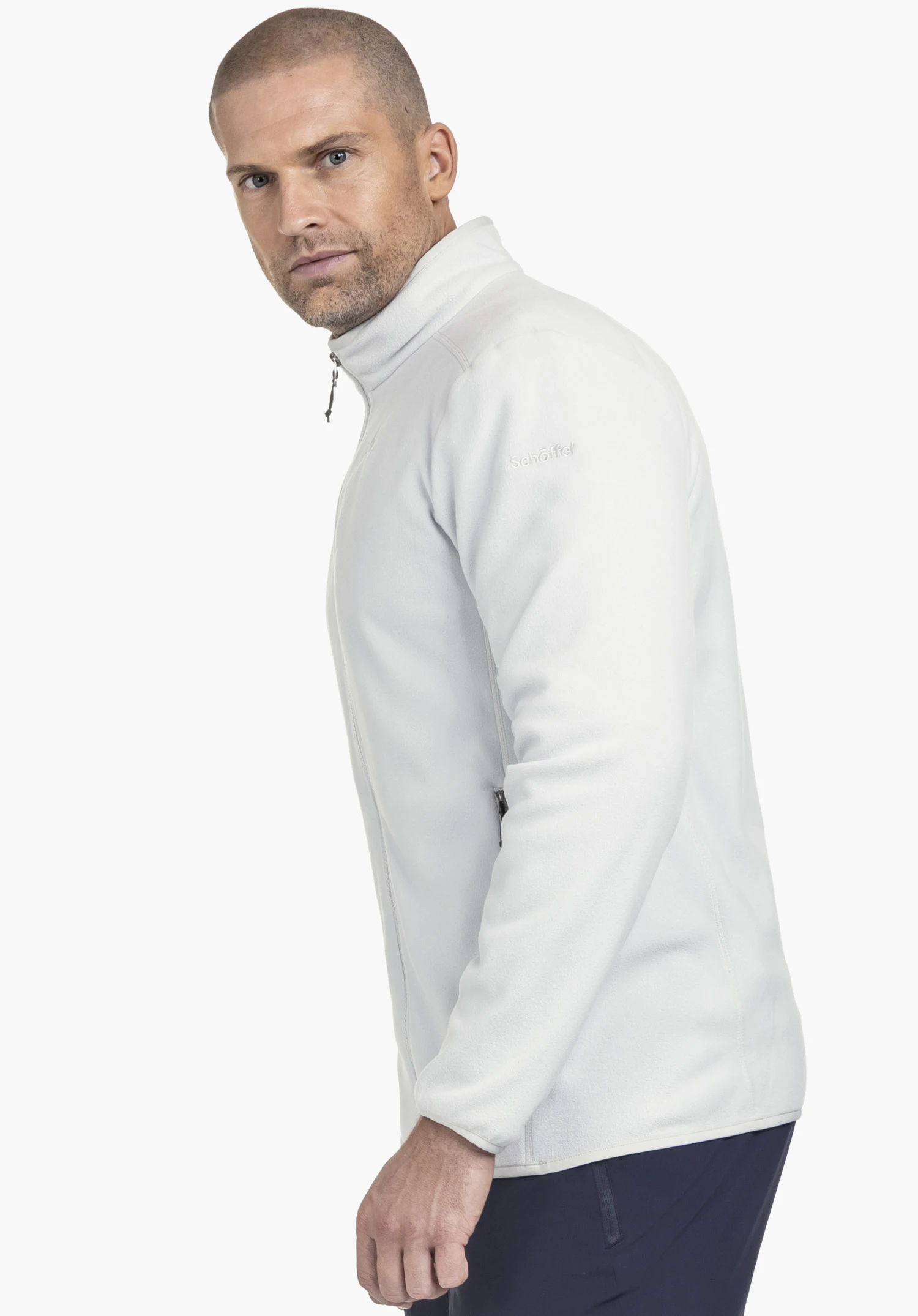 Fleece Jk Style Ash MNS: A male model is wearing the jacket in grey. The model is positioned in a slight profile view against a neutral background, highlighting the subtle Schöffel logo on the shoulder.