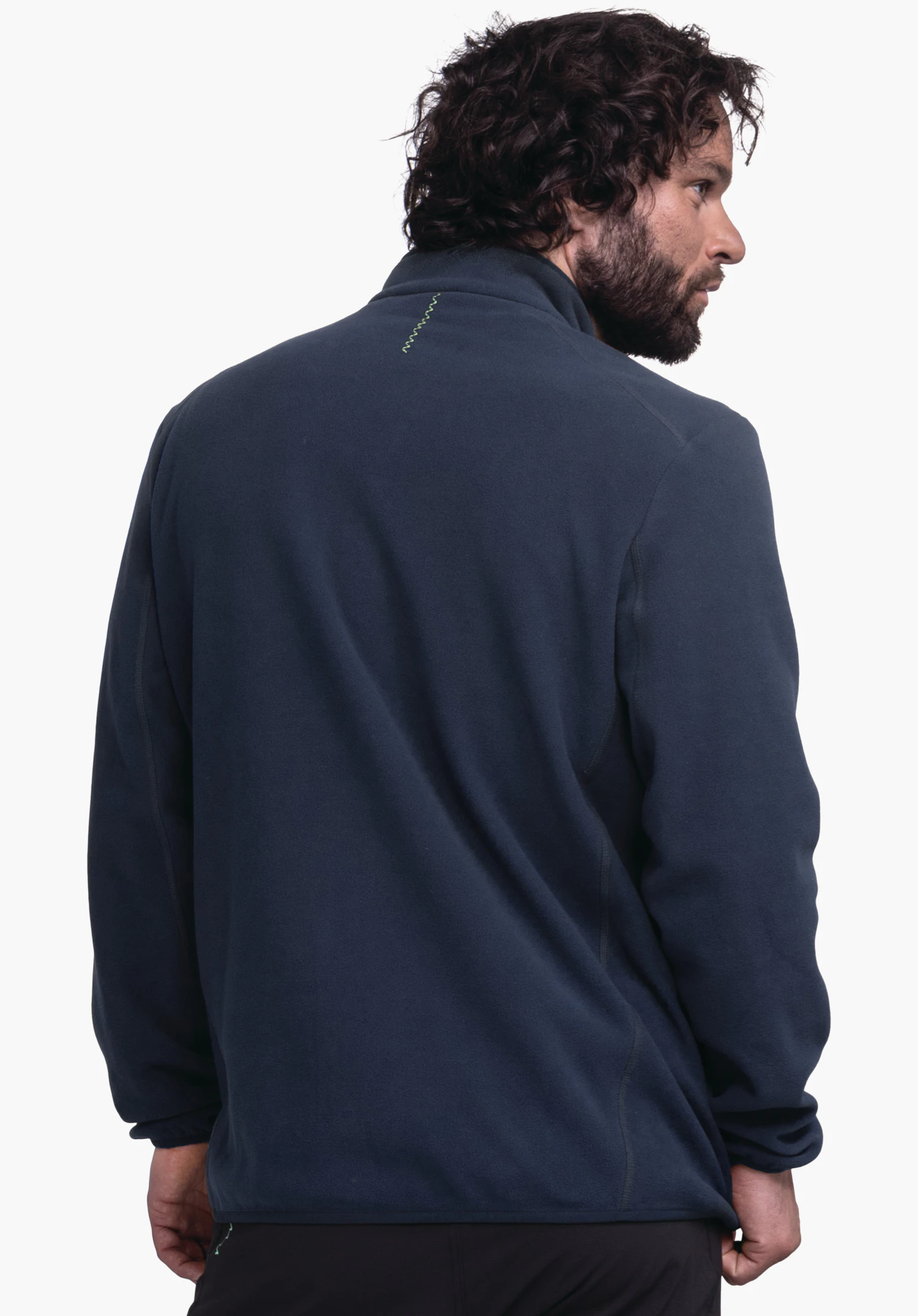 Fleece Jk Style Ash MNS dark blue fleece jacket worn by a man turning his torso slightly towards the viewer and turning his head right; small light green zigzag stitch at the neck; light background., Fleece Jk Style Ash MNS dark blue fleece jacket worn by a man turning his torso slightly towards the viewer and turning his head right; small light green zigzag stitch at the neck; light background.