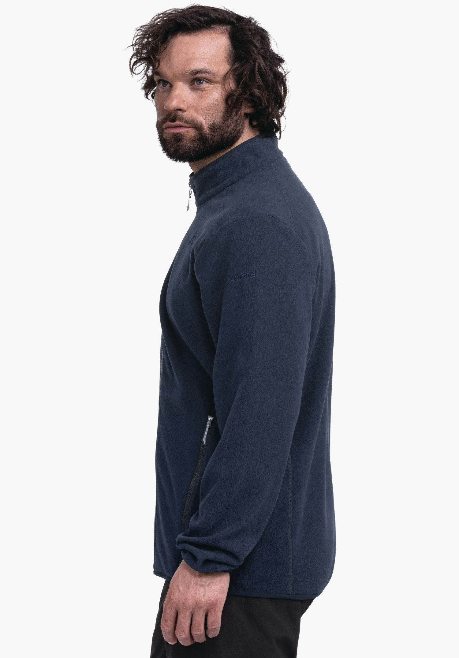 Fleece Jk Style Ash MNS dunkelblaue Fleecejacke, getragen von einem seitlich stehenden Mann mit Bart, der nach rechts oben blickt; Reißverschlusstaschen an der Seite; weißer Hintergrund. Text: "Schöffel".