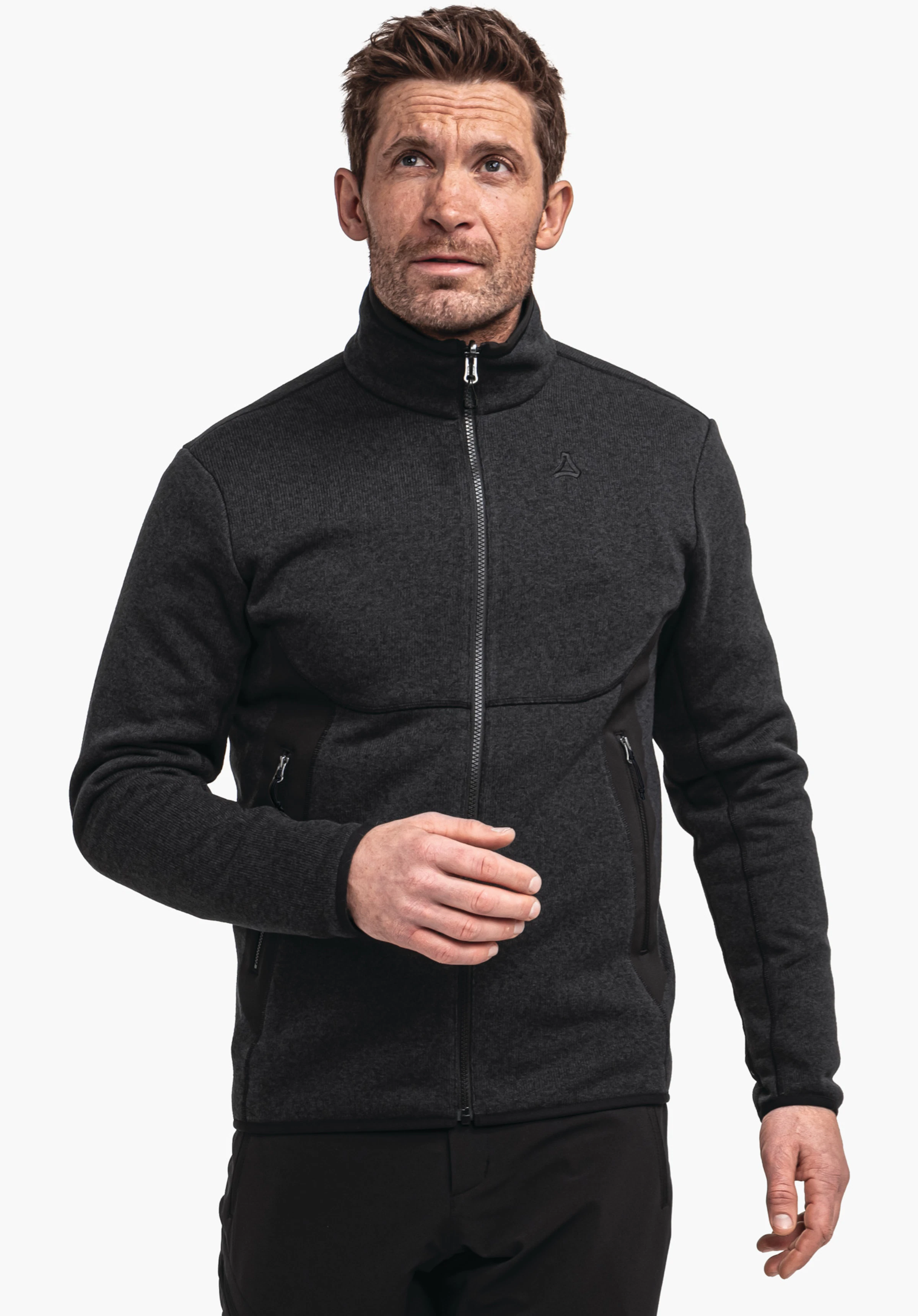 CIRC Fleece Jk Style Yew MNS homme portant une veste polaire noire profonde, fermant la fermeture éclair et regardant vers le haut; logo Schöffel sur la poitrine; fond blanc, prise de vue debout cadrée à la taille.