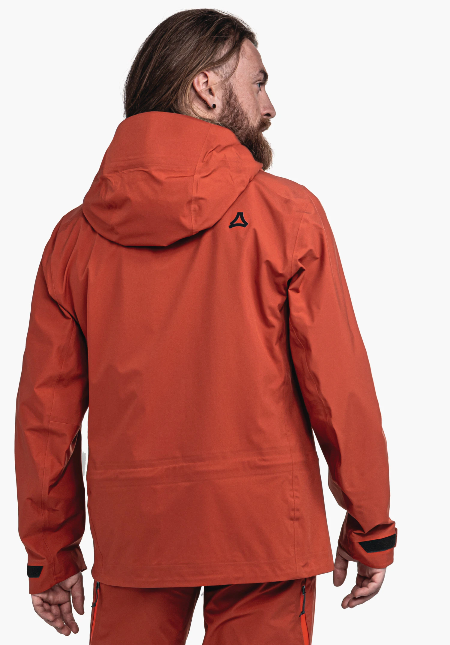 Jacket Style Milagle MNS dunkelrote Outdoorjacke mit Schöffel-Logo, getragen von einem Mann, steht mit dem Rücken zur Kamera; Kapuze angelegt, Hände entspannt, weißer neutraler Hintergrund.