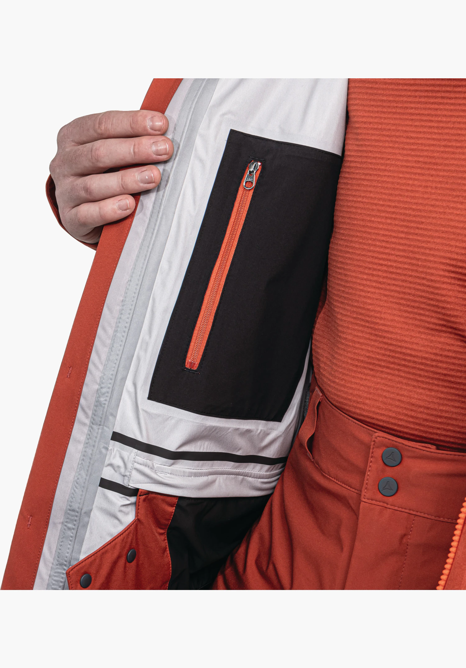 Jacket Style Milagle MNS zeigt die funktionale Innentasche mit rotem Reißverschluss auf schwarzem Einsatz sowie den integrierten Schneefang als Nahaufnahme vor weißem/neutralem Hintergrund.