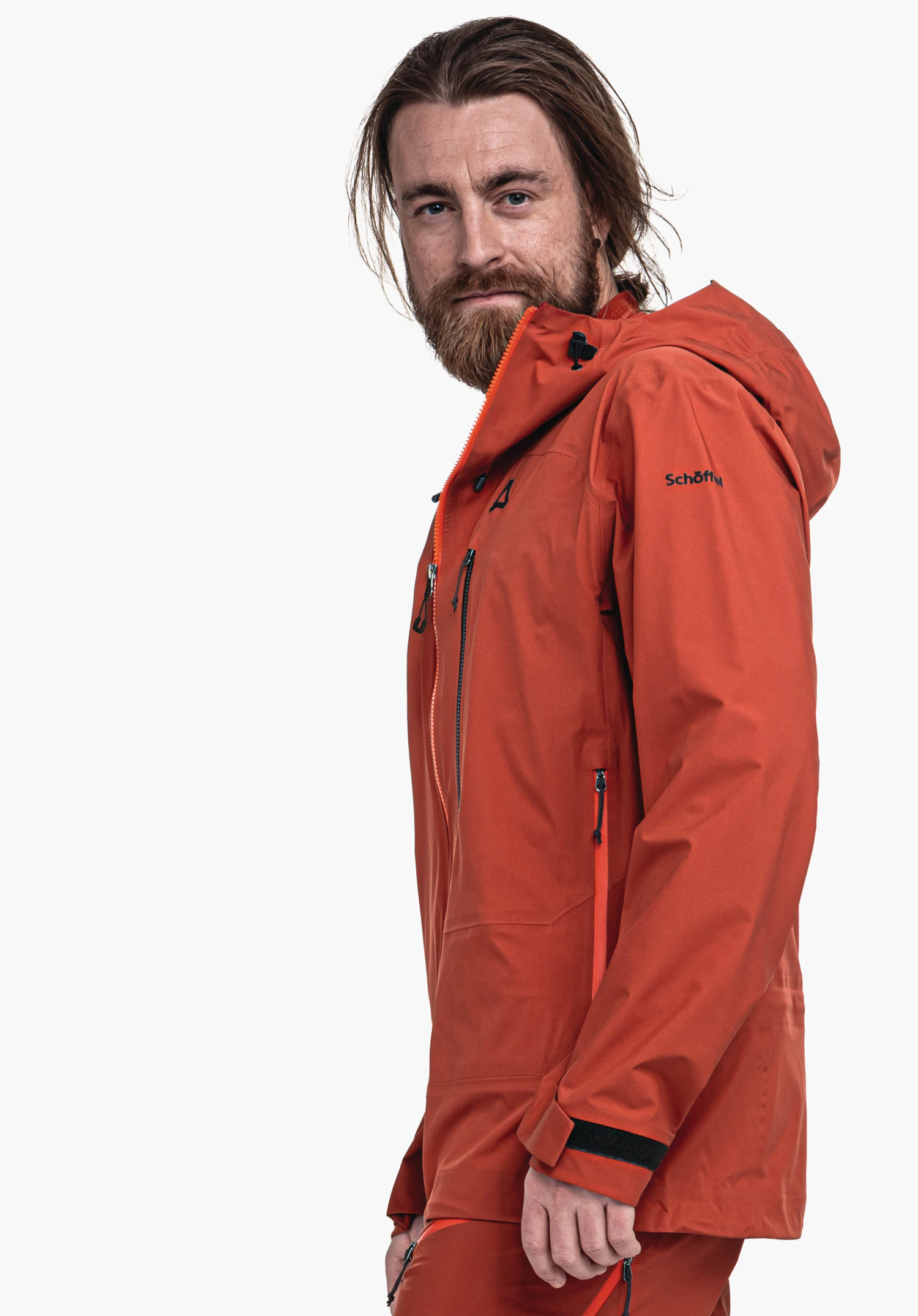 Jacket Style Milagle MNS rot Outdoorjacke: Mann trägt sie mit Kapuze; Schöffel-Logo auf der Brust, Schriftzug "Schöffel" auf dem Ärmel; seitliche Pose vor weißem Hintergrund.